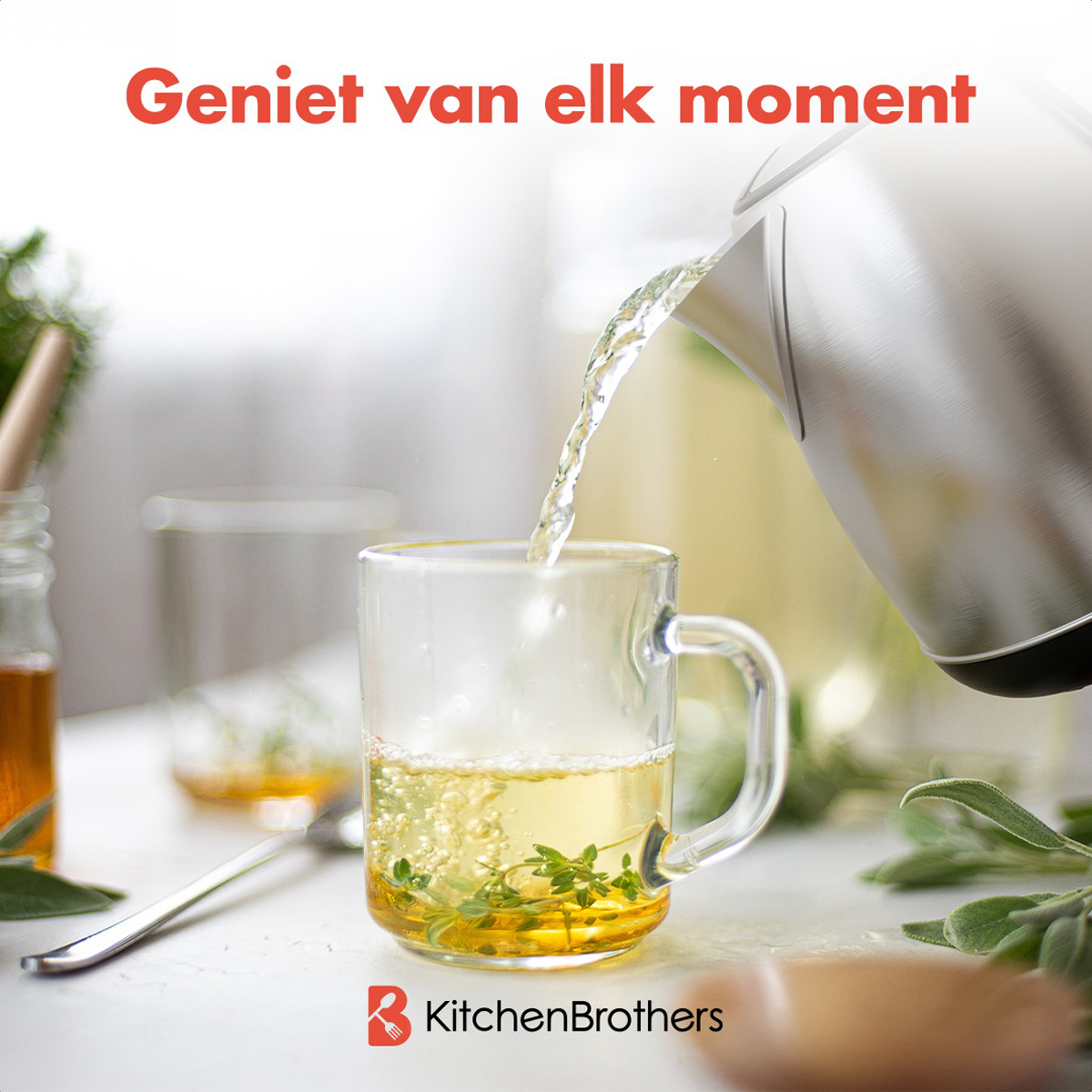 Een persoon schenkt thee uit een zilveren waterkoker in een glas met munt en kruiden.