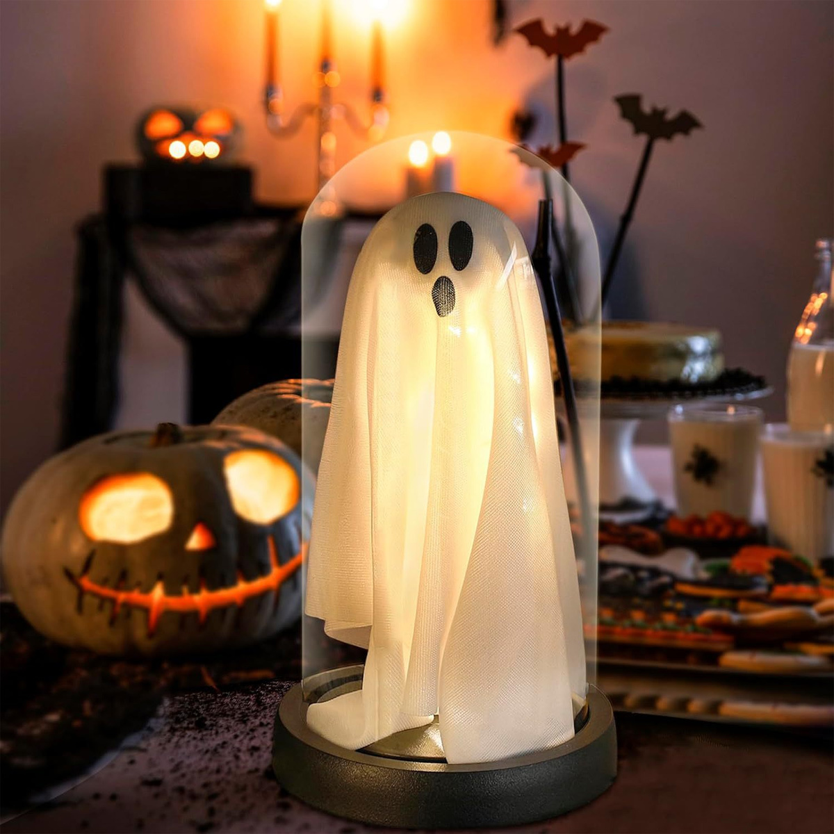 Halloween-Dekoration mit einem Geist unter einer Glaskuppel, Kürbis, Kerzen und Dekorationen.