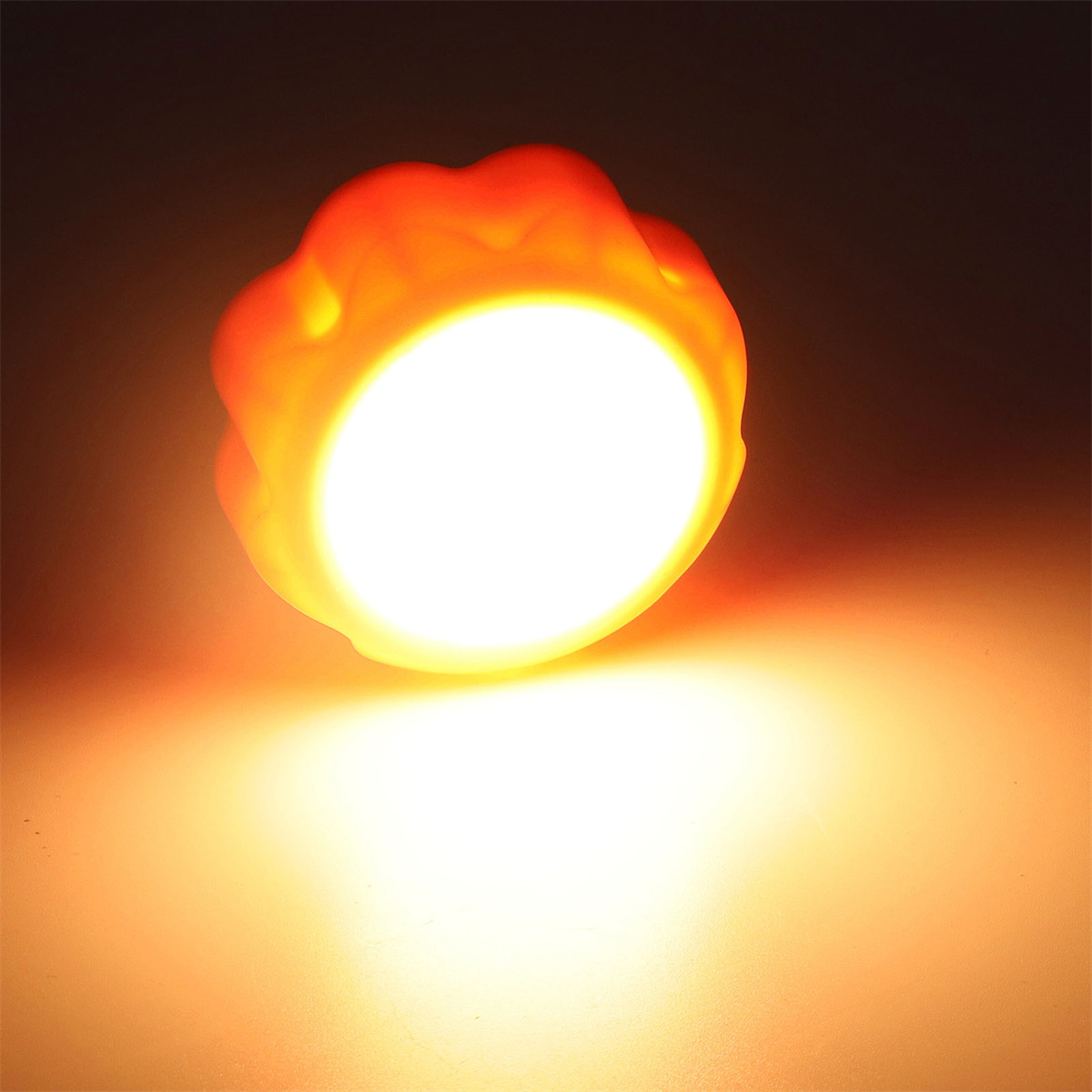 Leuchtende orange Lichtquelle. Kreisförmige Form mit strukturierter Kante. Dunkler Hintergrund.