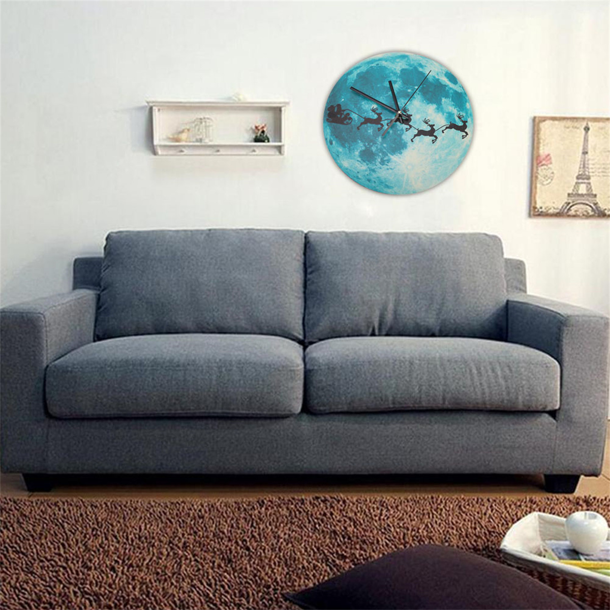 Blauer Mond-Uhr mit Weihnachtsmann und Rentieren über einem grauen Sofa.
