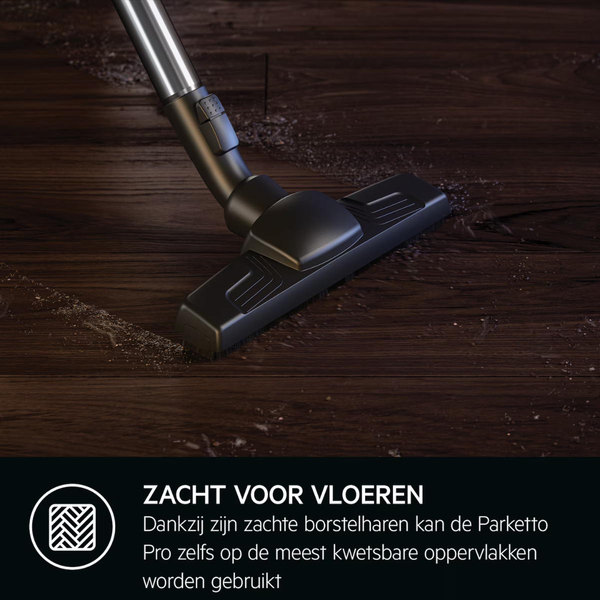 Een stofzuigerkop die een donkere houten vloer schoonmaakt.
