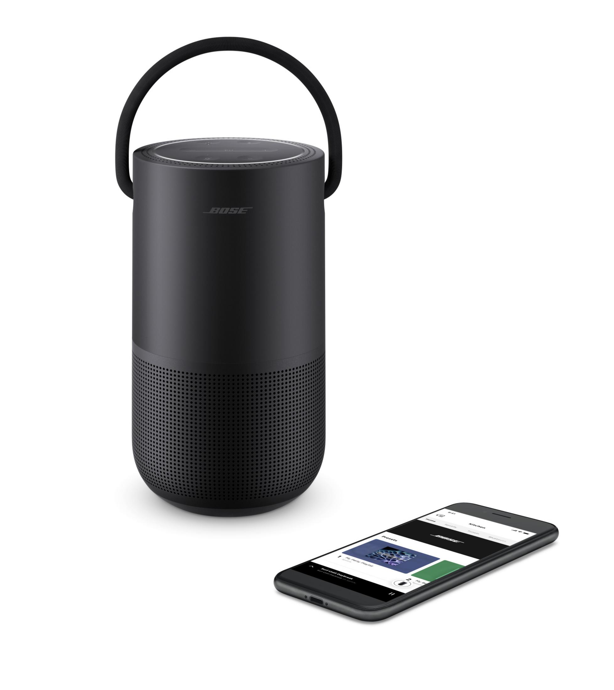 Altavoz Bose negro con un teléfono que muestra música. El altavoz tiene un asa.
