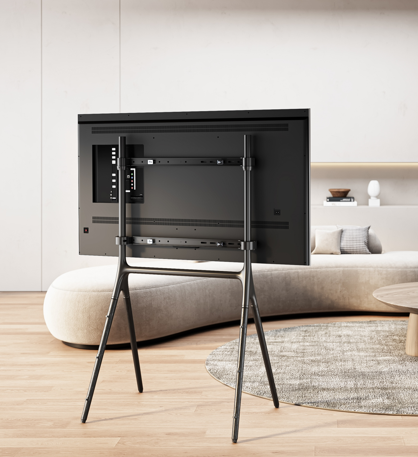 Zwarte tv-standaard met een grote tv erop in een moderne woonkamer.