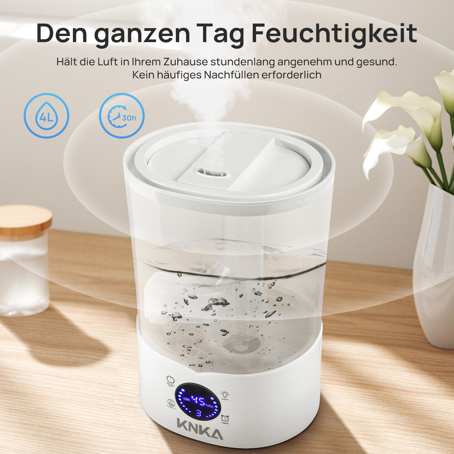 Luftbefeuchter mit Wasser im Inneren. Text auf Deutsch. Vase mit Blumen an der Seite.