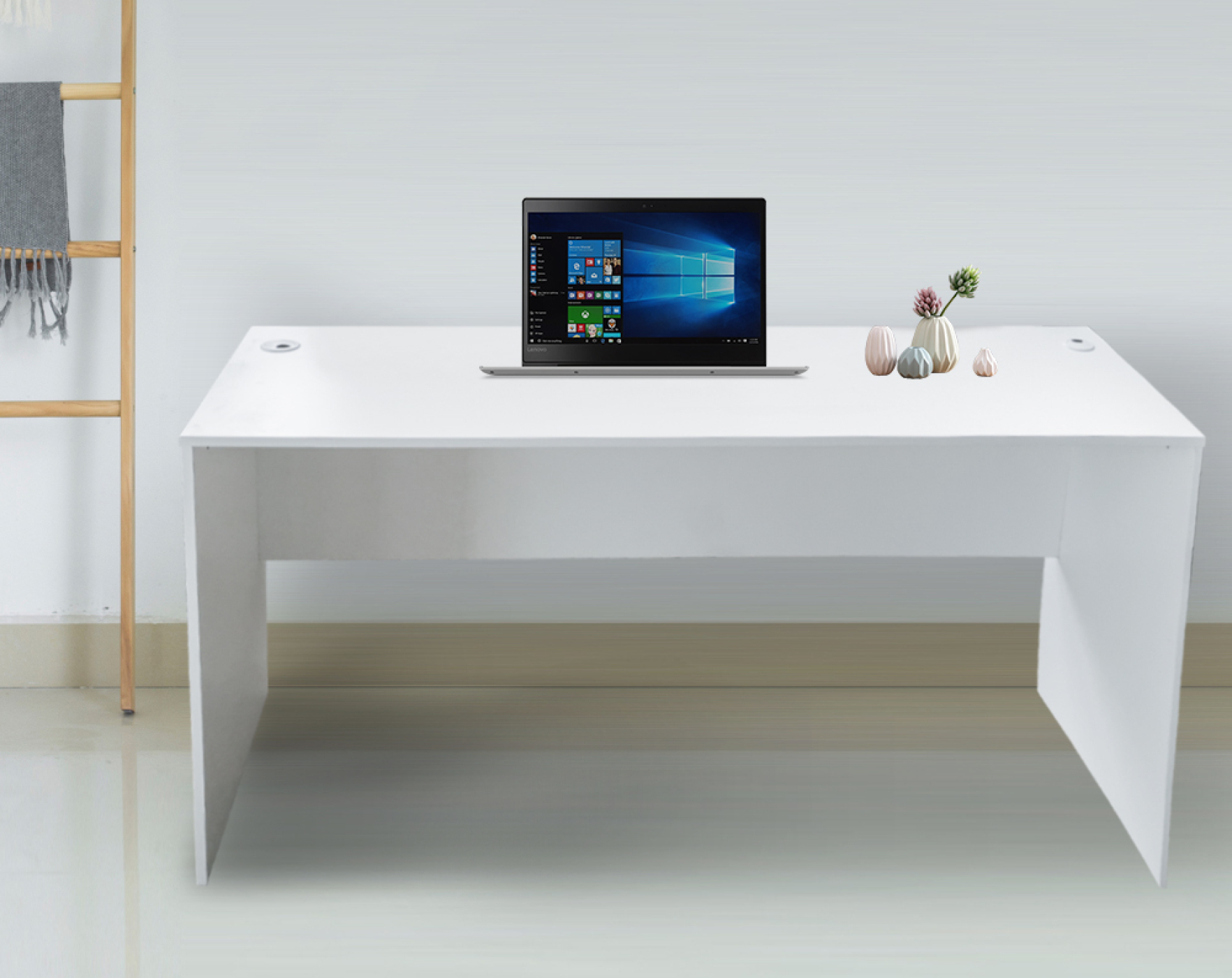 Ein Laptop auf einem weißen Schreibtisch mit Vasen und einer Holzleiter im Hintergrund.