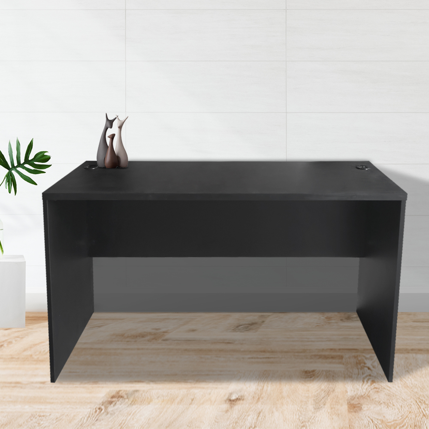 Zwarte bureautafel op een houten vloer met decoratieve items.