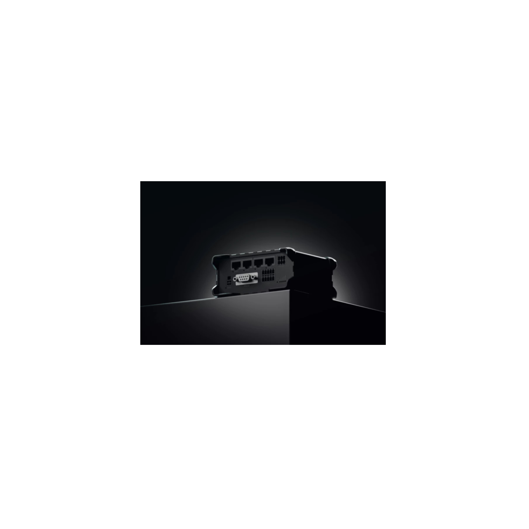 A black device with ports. The device is on a black surface. The background is dark.