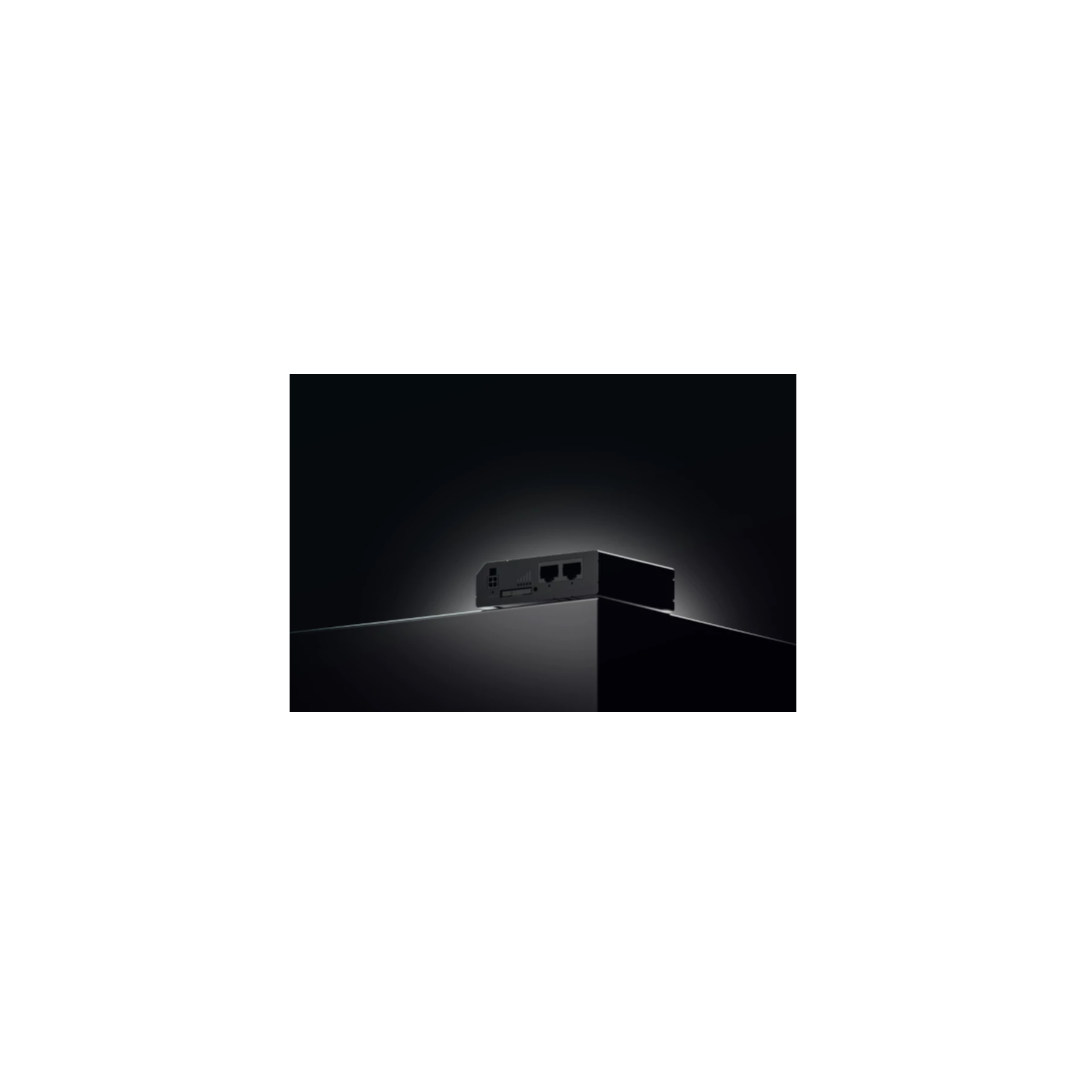 Appareil noir avec ports, sur une surface noire, avec un fond sombre.