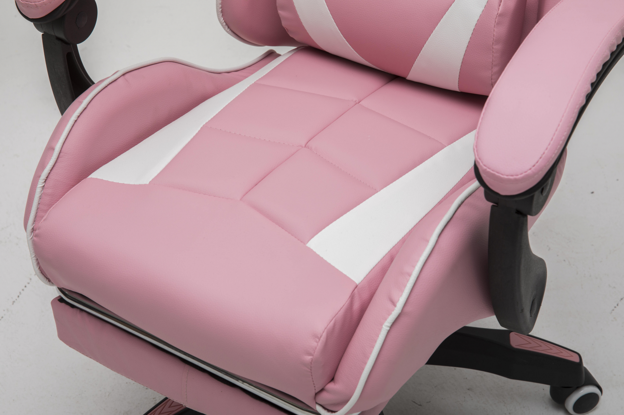 Close-up van een roze en witte gamingstoel met witte accenten. Witte achtergrond.