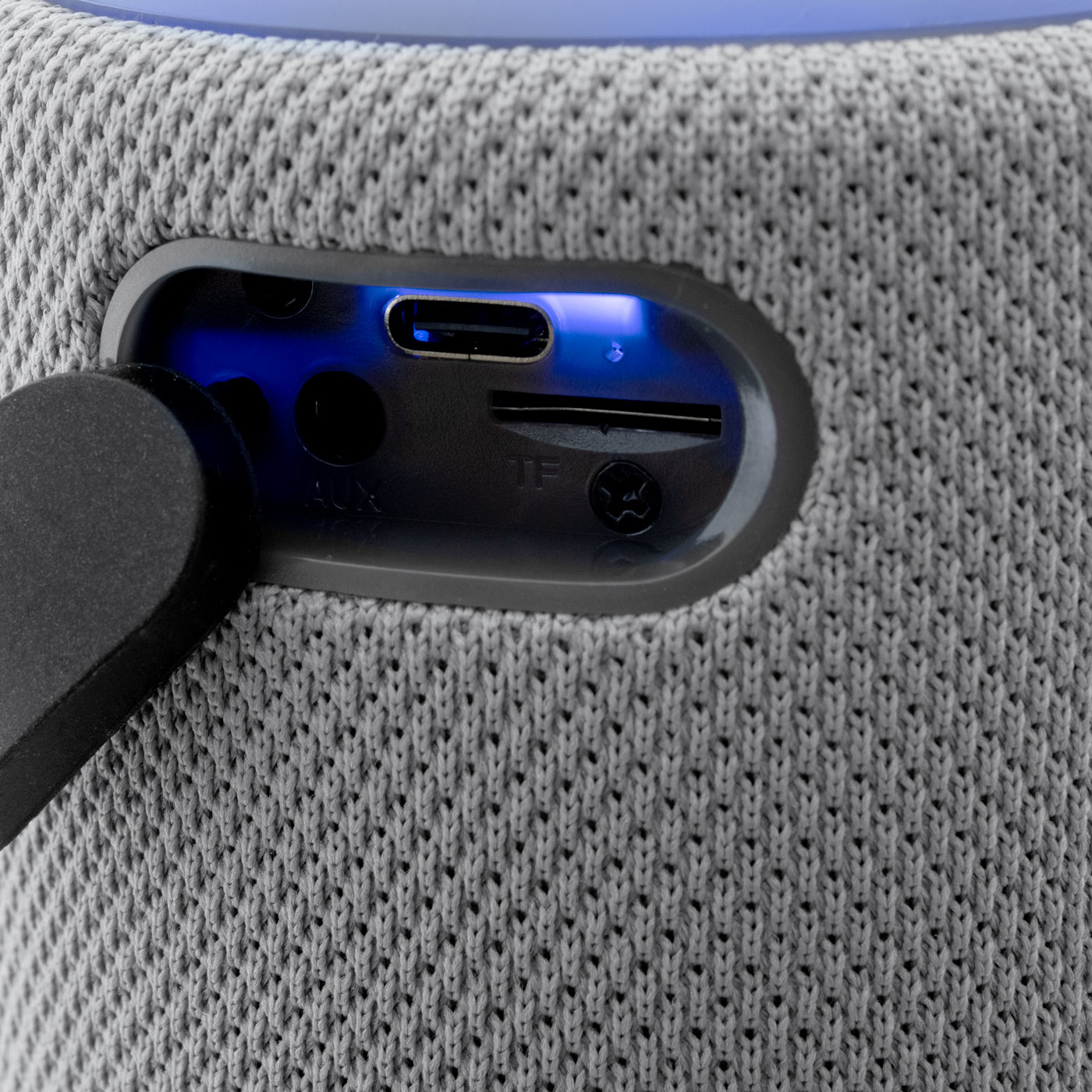 Szary głośnik z portami. Porty obejmują AUX, SD i port USB z niebieskim światłem.