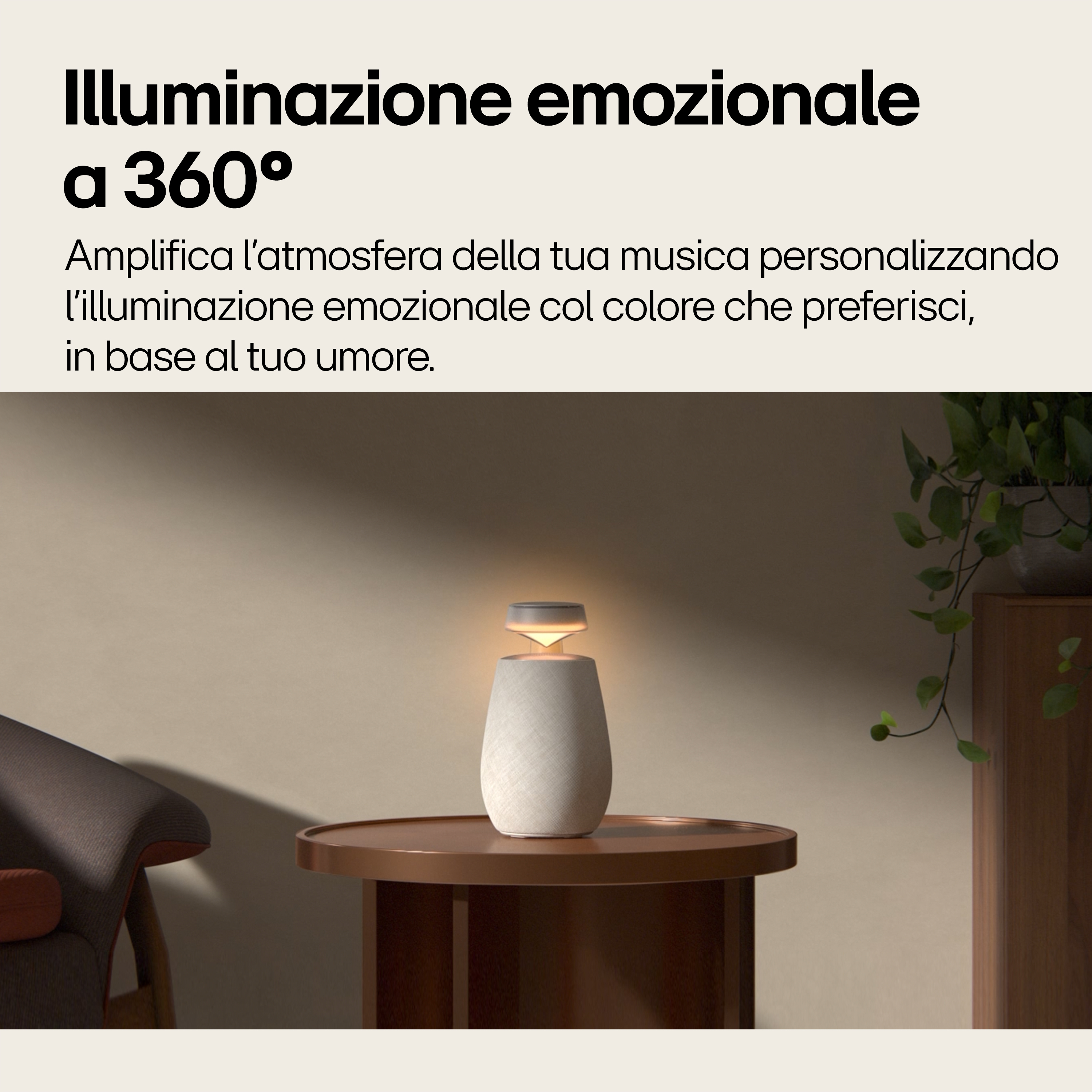 Witte en beige luidspreker op een tafel met licht, naast een bank en een kast.