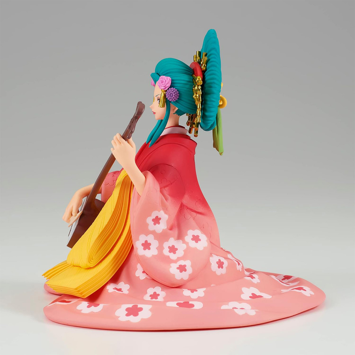 Figura de mujer en kimono rosa floral tocando instrumento de cuerda, con tocado ornamental.