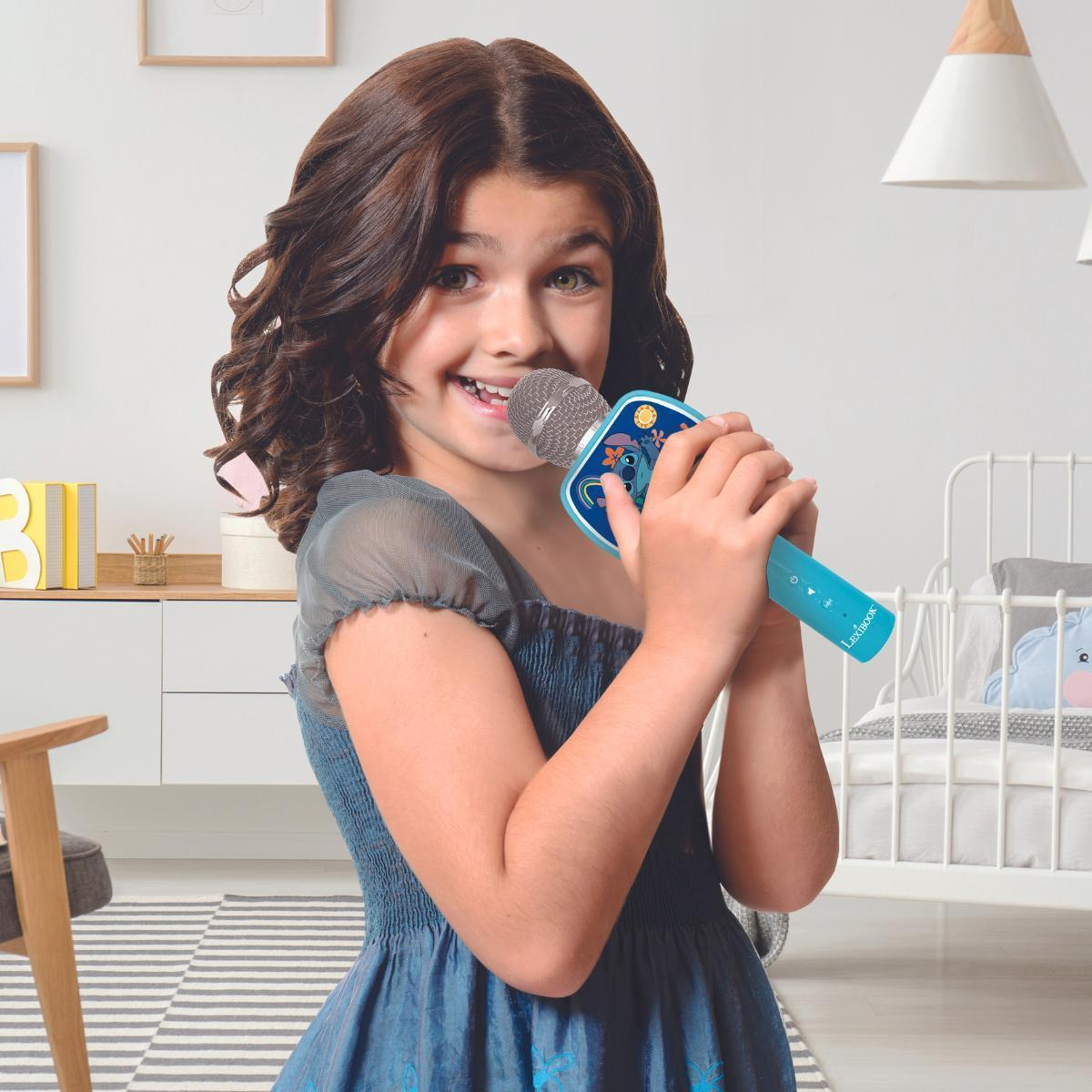 Dziewczynka śpiewa do niebieskiego mikrofonu. Uśmiecha się i jest szczęśliwa. W tle sypialnia.