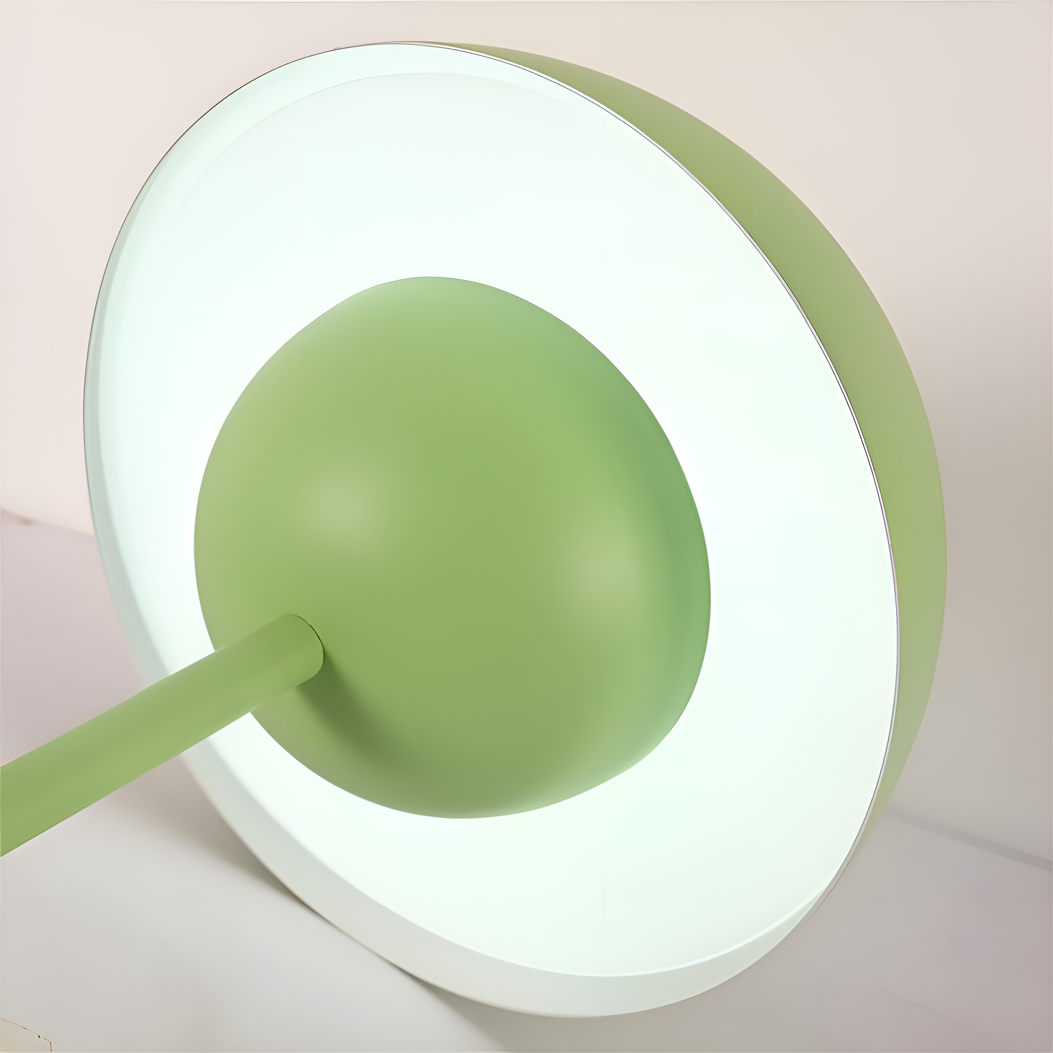 Grüne Lampe mit rundem Schirm und grünem Stiel. Weißer Hintergrund.