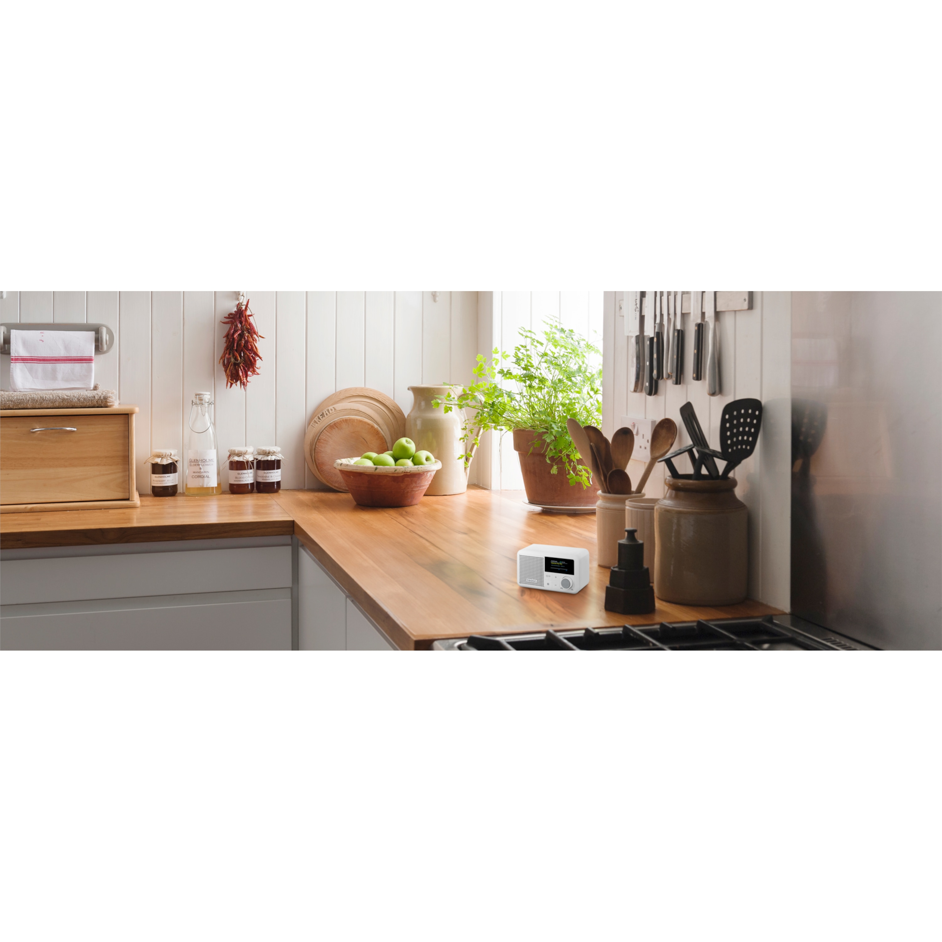 A modern kitchen scene with a digital radio on a wooden countertop.