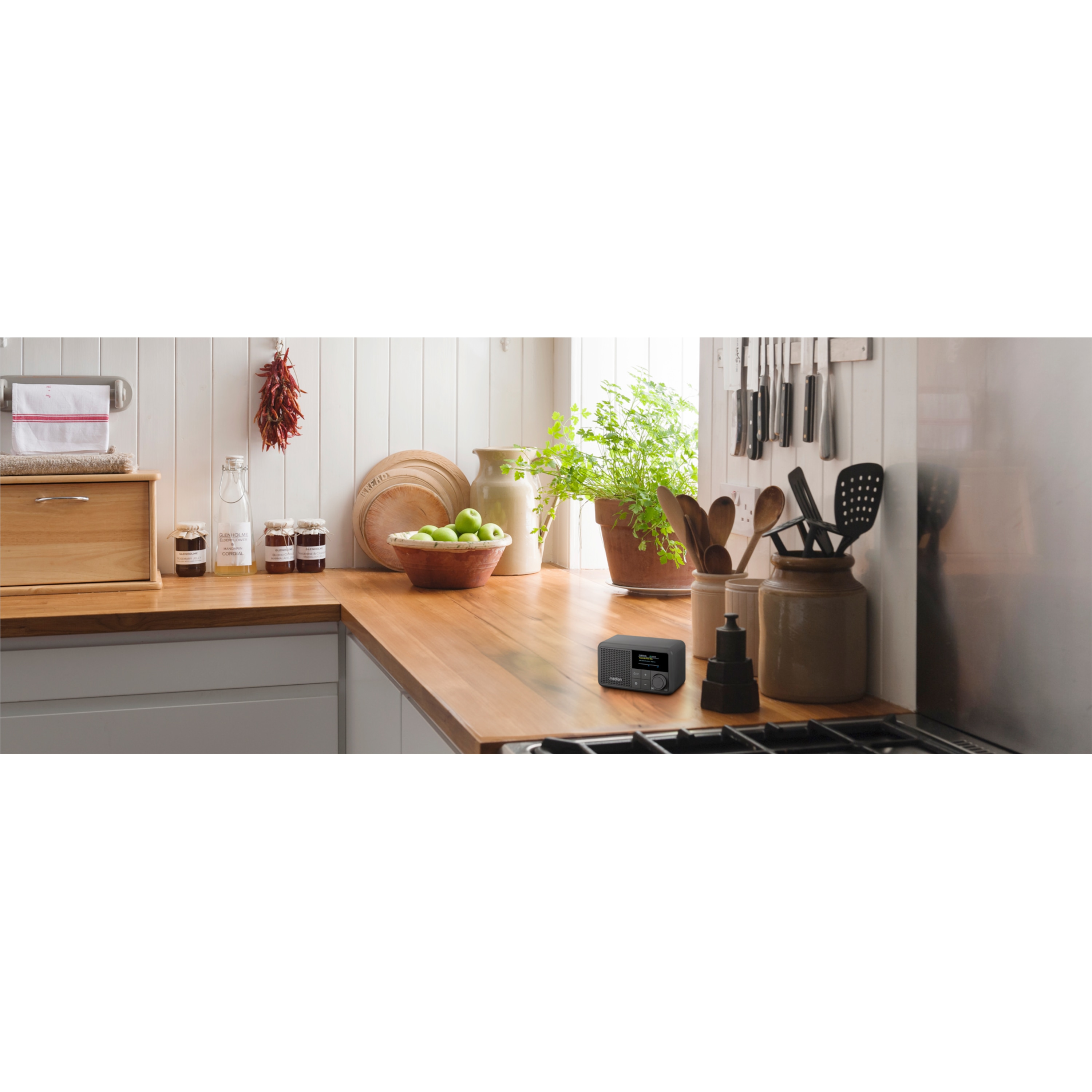A modern kitchen scene with a black digital radio on a wooden countertop.