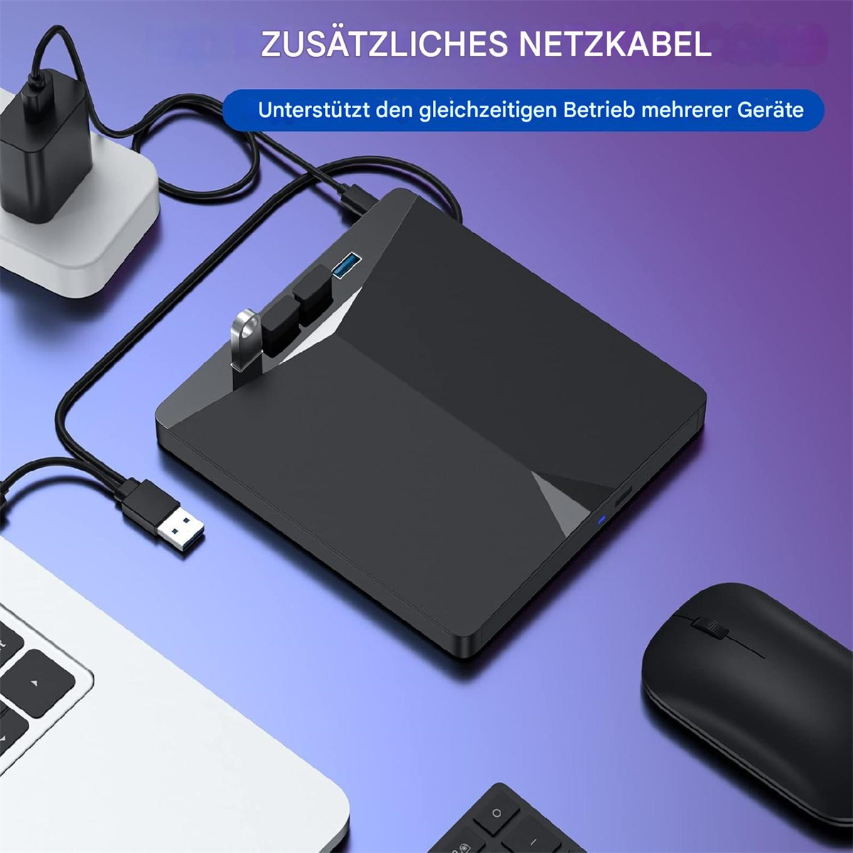 Ein schwarzes Gerät mit angeschlossenem USB- und Netzkabel, umgeben von Laptop, Maus und Tastatur.