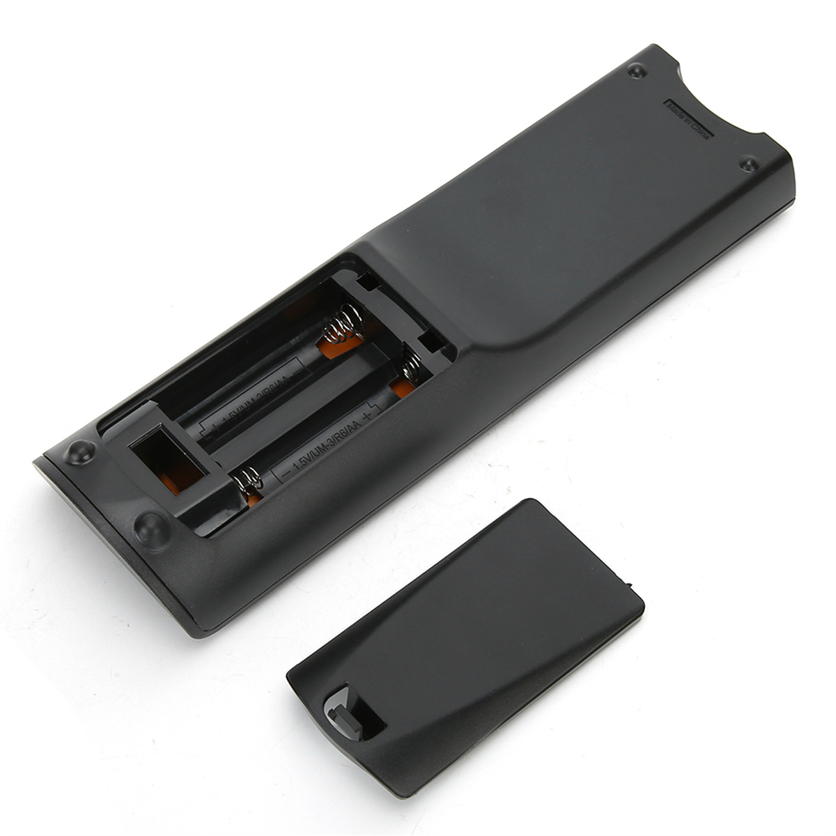 Die offene Rückseite einer schwarzen Fernbedienung mit Batterien und abgenommener Abdeckung.