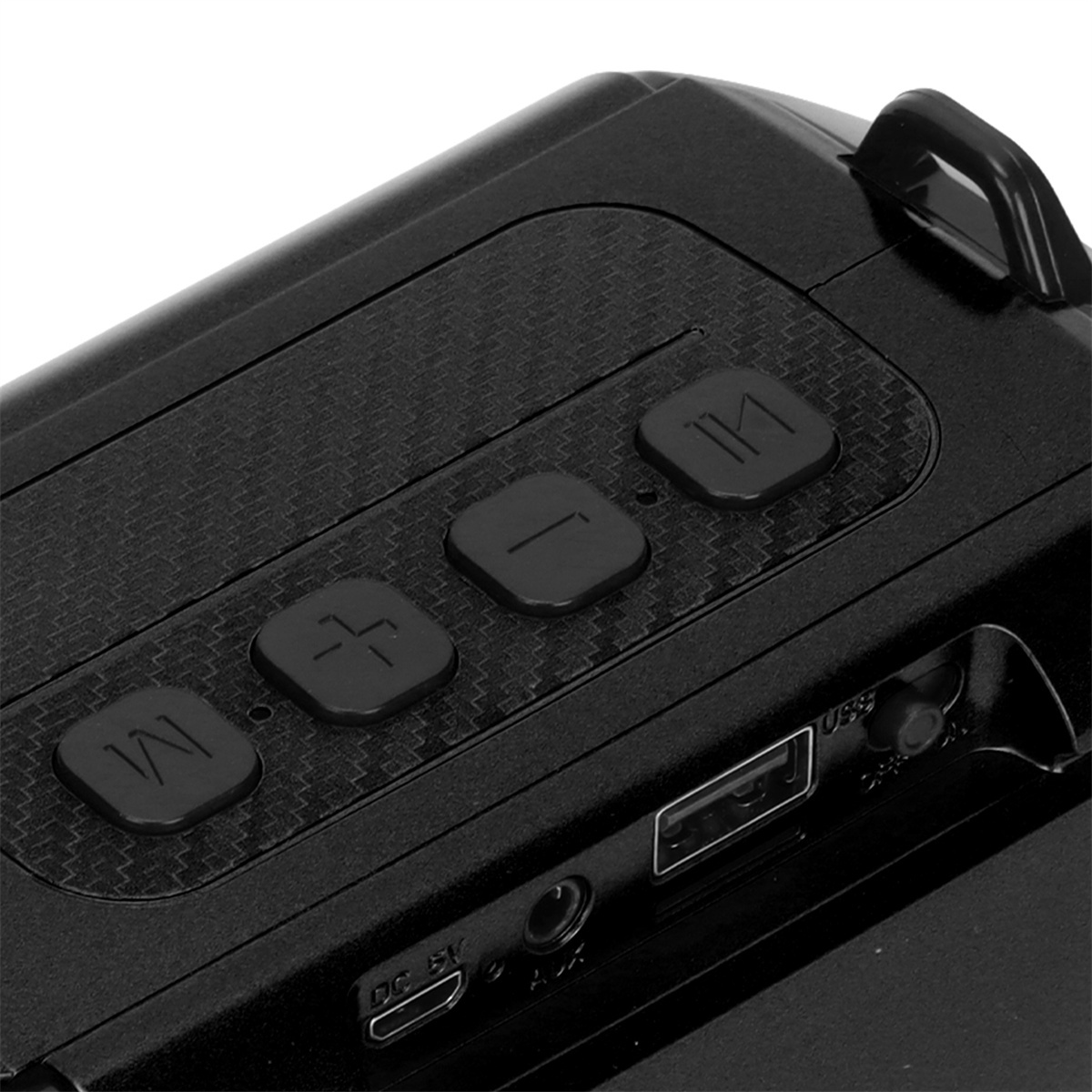 Nahaufnahme eines schwarzen Lautsprechers mit drei Knöpfen, einem USB-Anschluss und anderen Anschlüssen auf einer strukturierten Oberfläche.