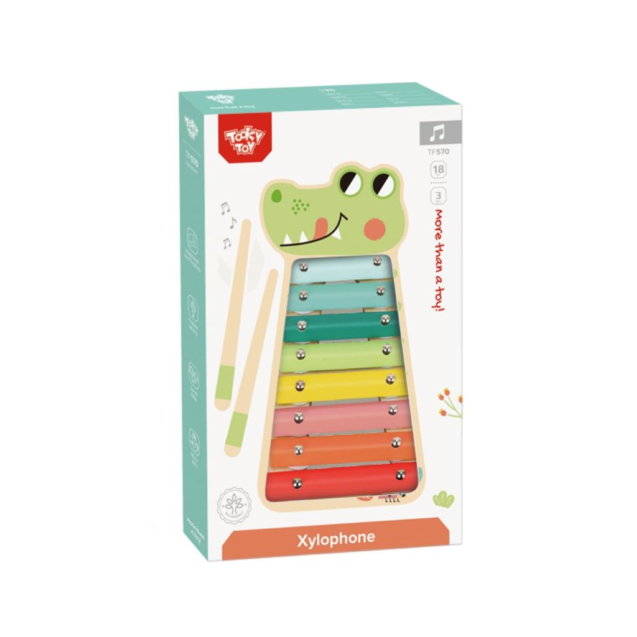 Xylophon-Spielzeug in einer Box. Die Box hat eine grüne Krokodil-Illustration und Noten.