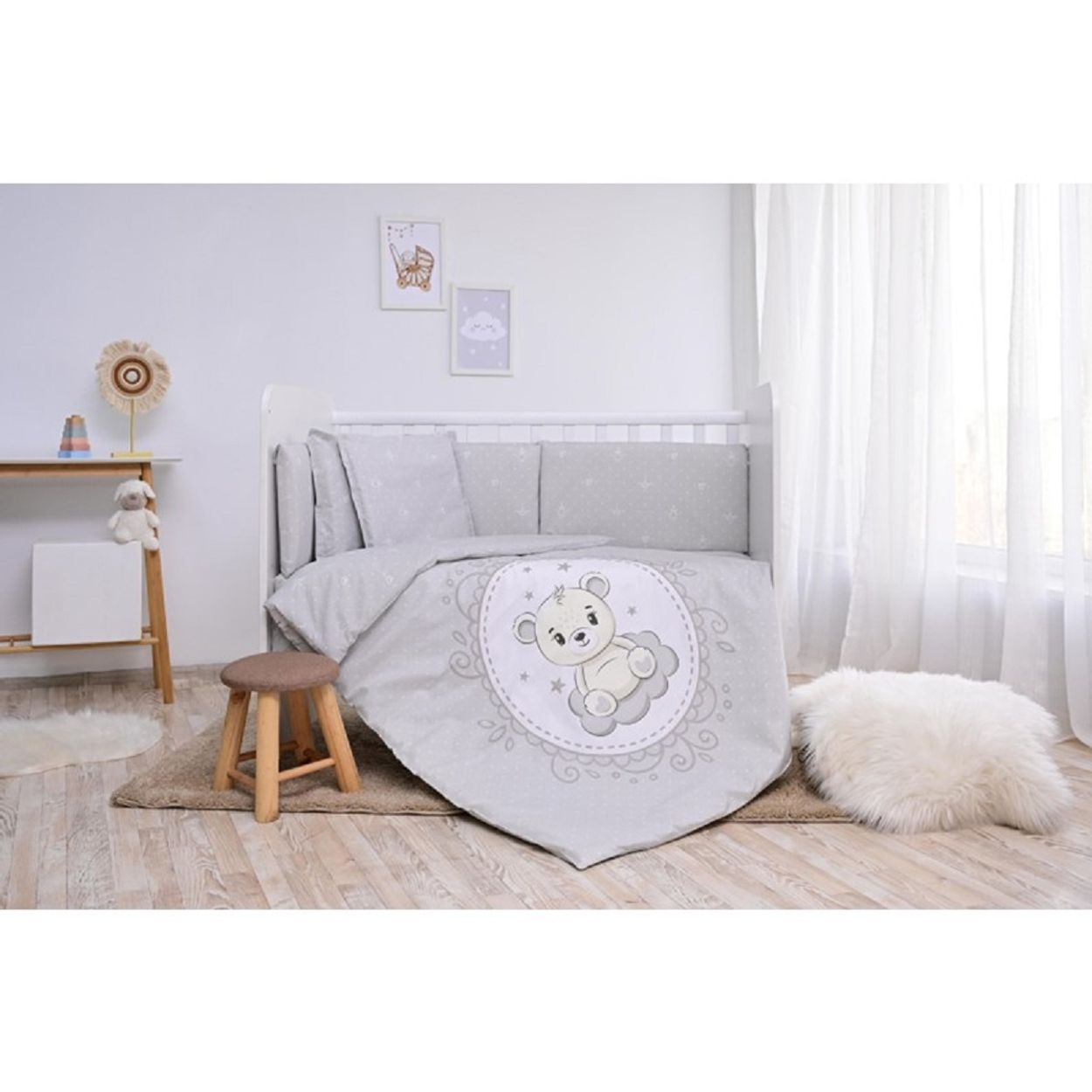 Babybettwäsche auf einem weißen Kinderbett, mit Teddybären-Design. Holzfußboden und weiße Wand.