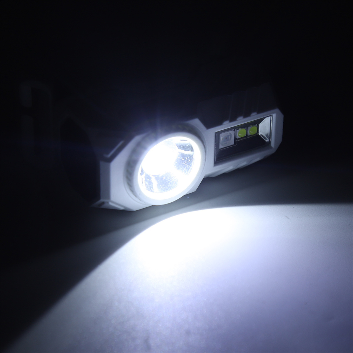 Eine Taschenlampe, die helles Licht in die Dunkelheit scheint. Weißes Gehäuse.
