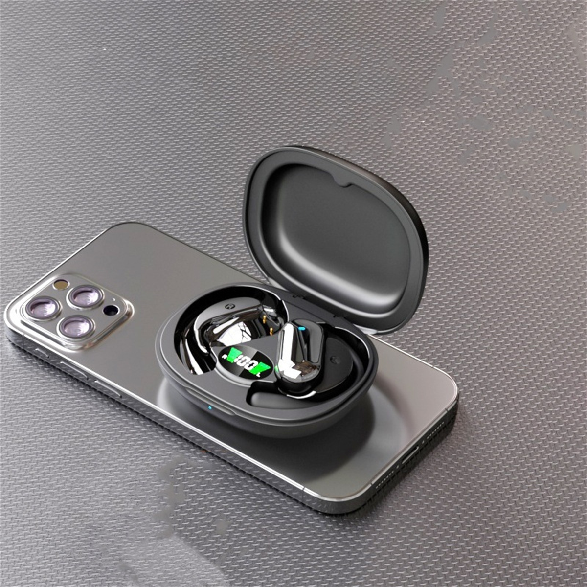 Schwarzes Gehäuse mit kabellosen Ohrhörern auf einem Telefon. Dunkle Oberfläche.