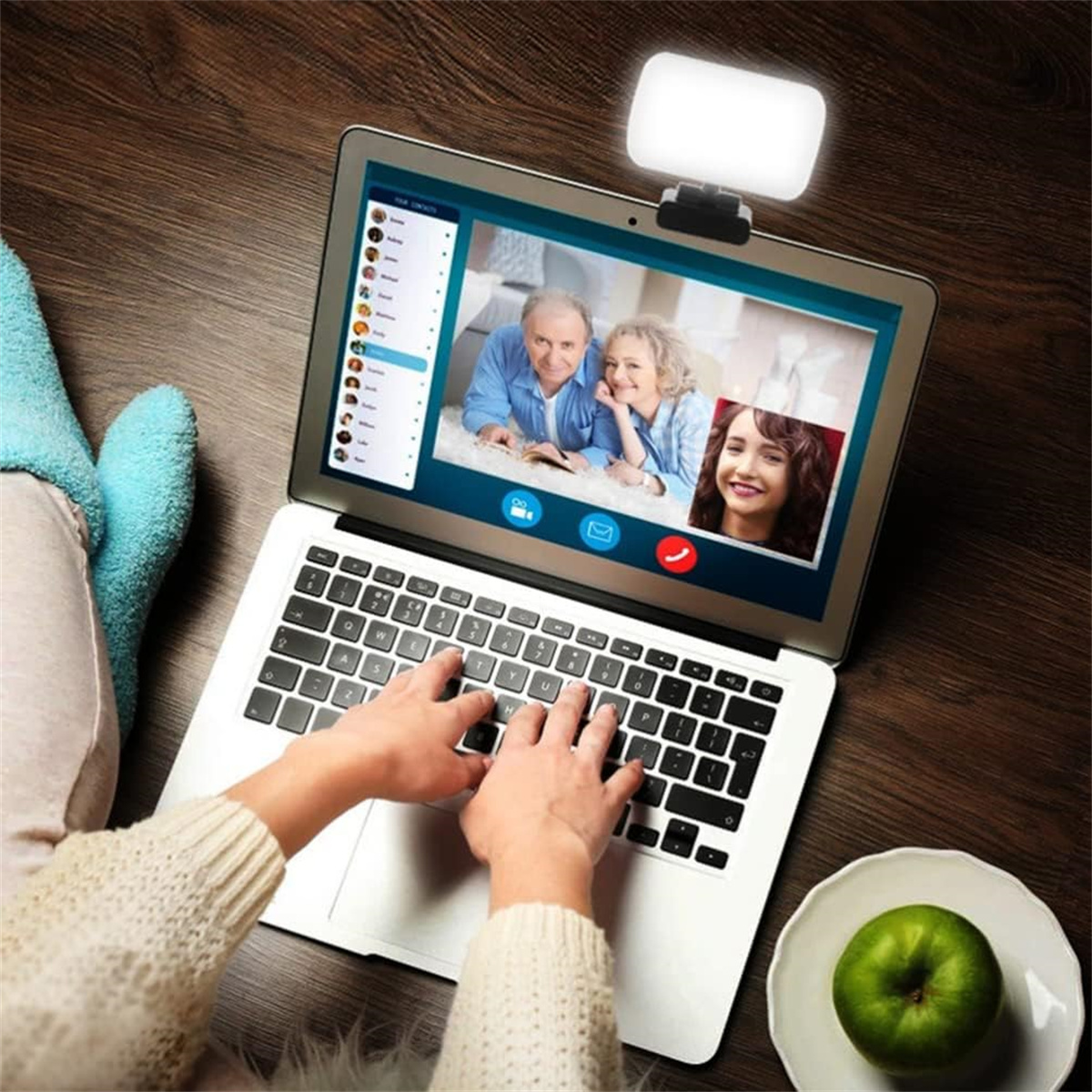 Eine Person benutzt einen Laptop für einen Videoanruf. Der Bildschirm zeigt eine Familie und einen Freund.