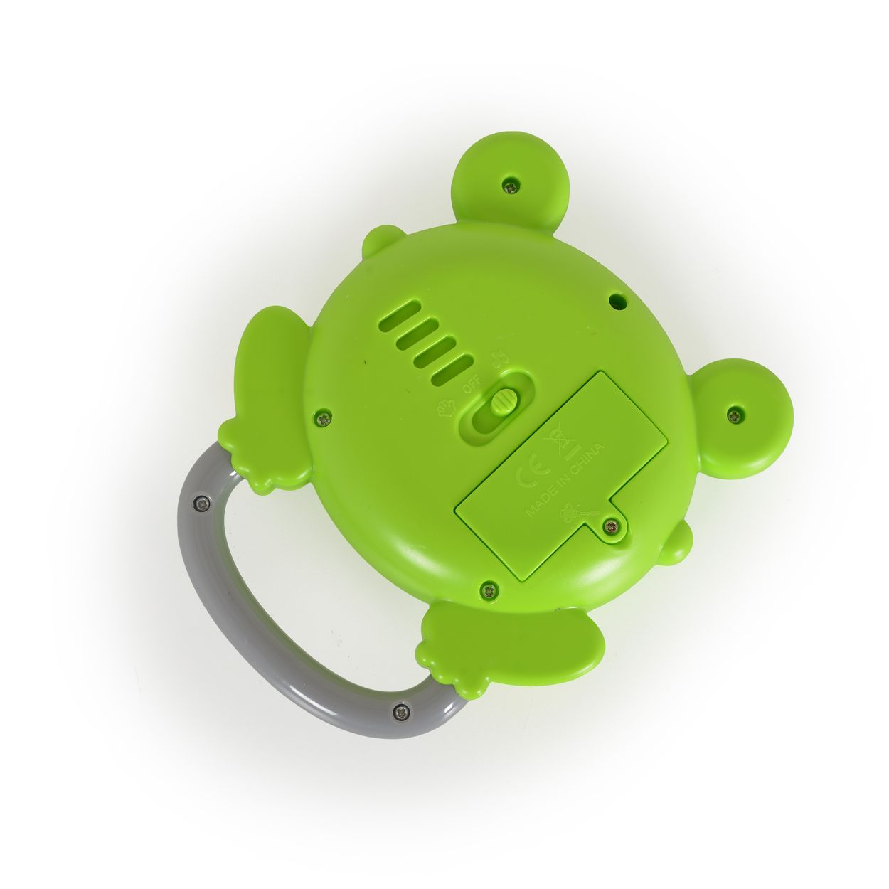 Ein grünes froschförmiges Spielzeug mit Griff, auf weißem Hintergrund, mit Knöpfen und Batteriefach.