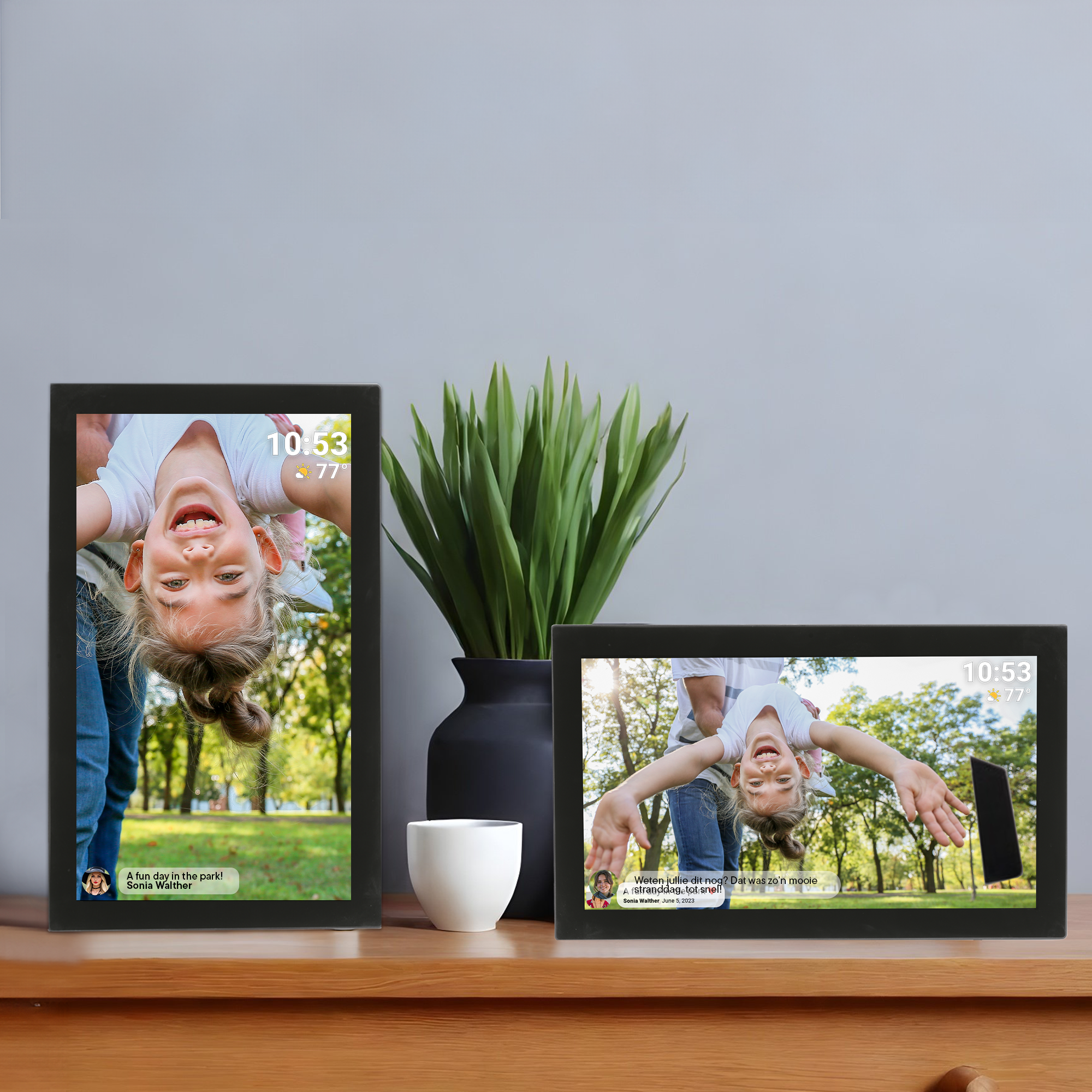 Dwie czarne cyfrowe ramki na zdjęcia wyświetlające zdjęcia dziewczynki, umieszczone na drewnianej powierzchni.