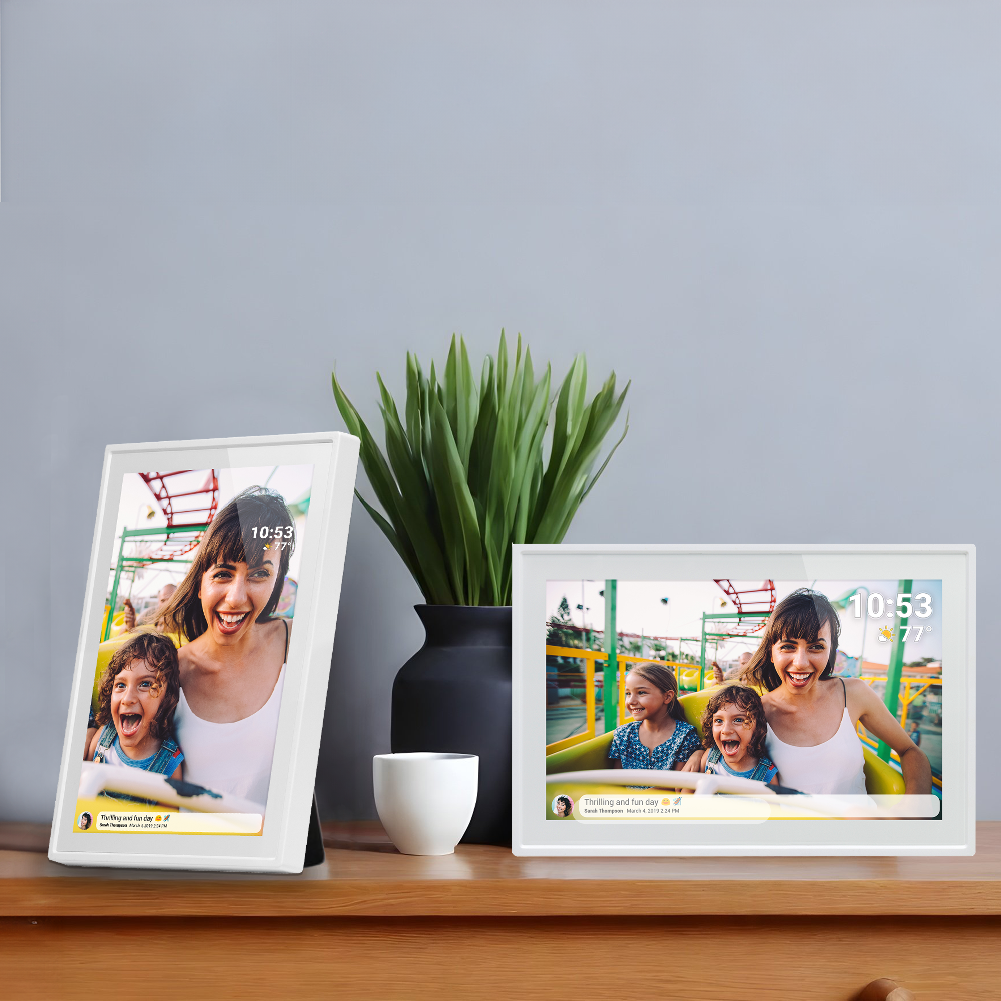 Deux cadres photo numériques blancs affichant des photos d'une femme et d'enfants sur une table en bois.