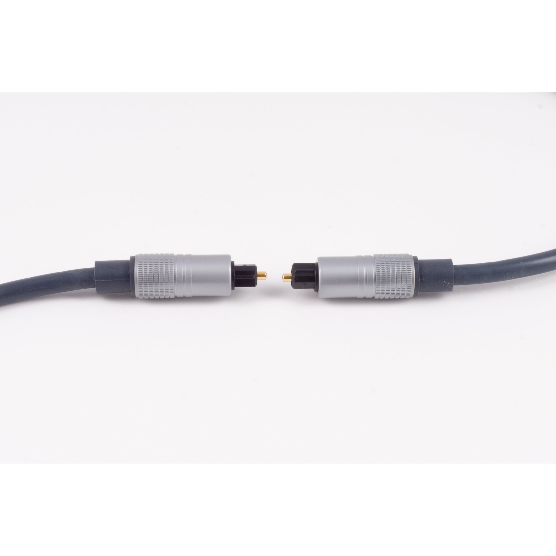 Zwei optische Audiokabel mit silbernen Steckern, die Enden zeigen auf weißem Hintergrund aufeinander zu.