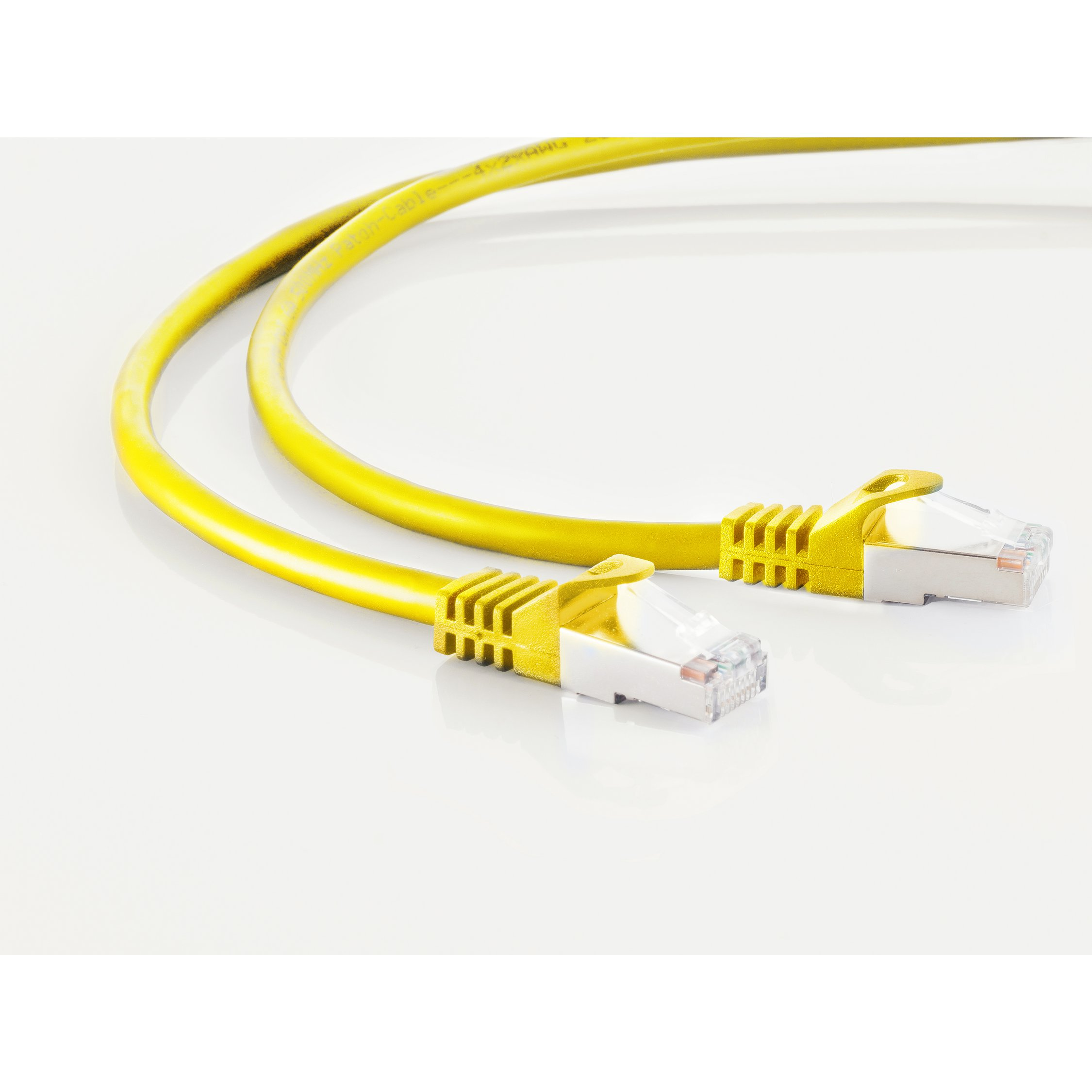 Żółty kabel Ethernet z wtykami RJ45, na białej powierzchni.