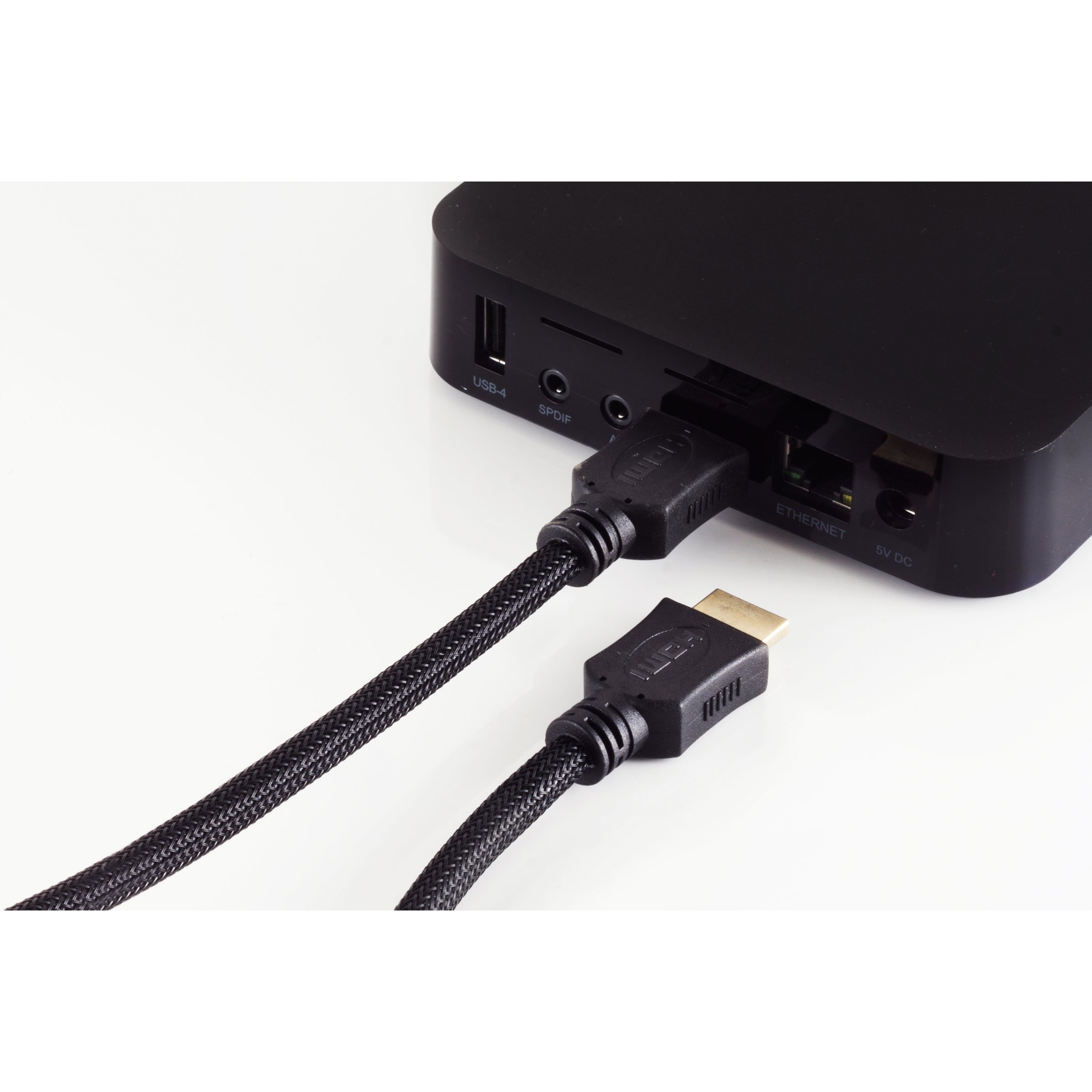 Schwarzes Gerät mit angeschlossenem HDMI-Kabel, USB und andere Anschlüsse sichtbar, auf weißem Hintergrund.