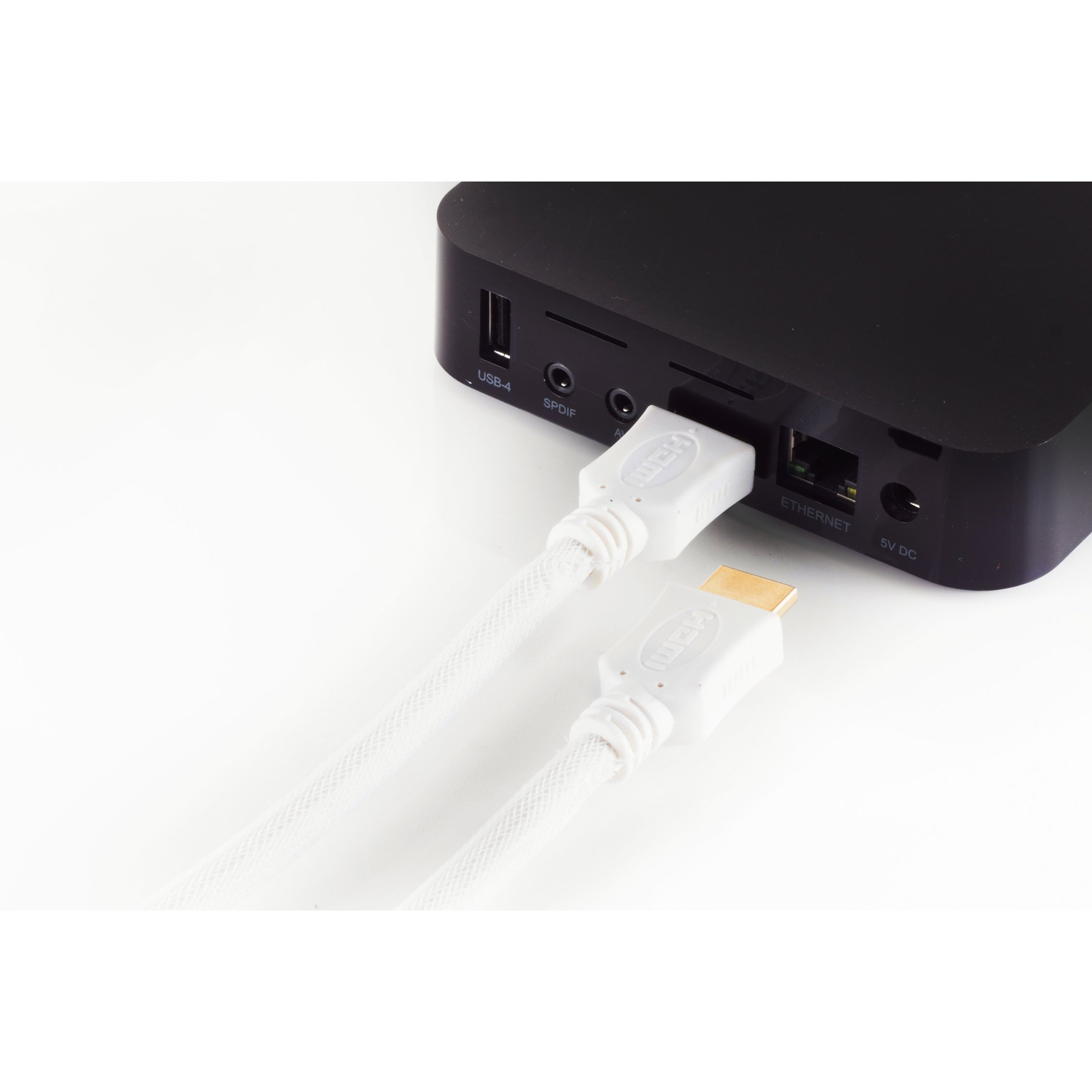 Weißes HDMI-Kabel an schwarzes Gerät angeschlossen, anderes Kabel in der Nähe, weißer Hintergrund.