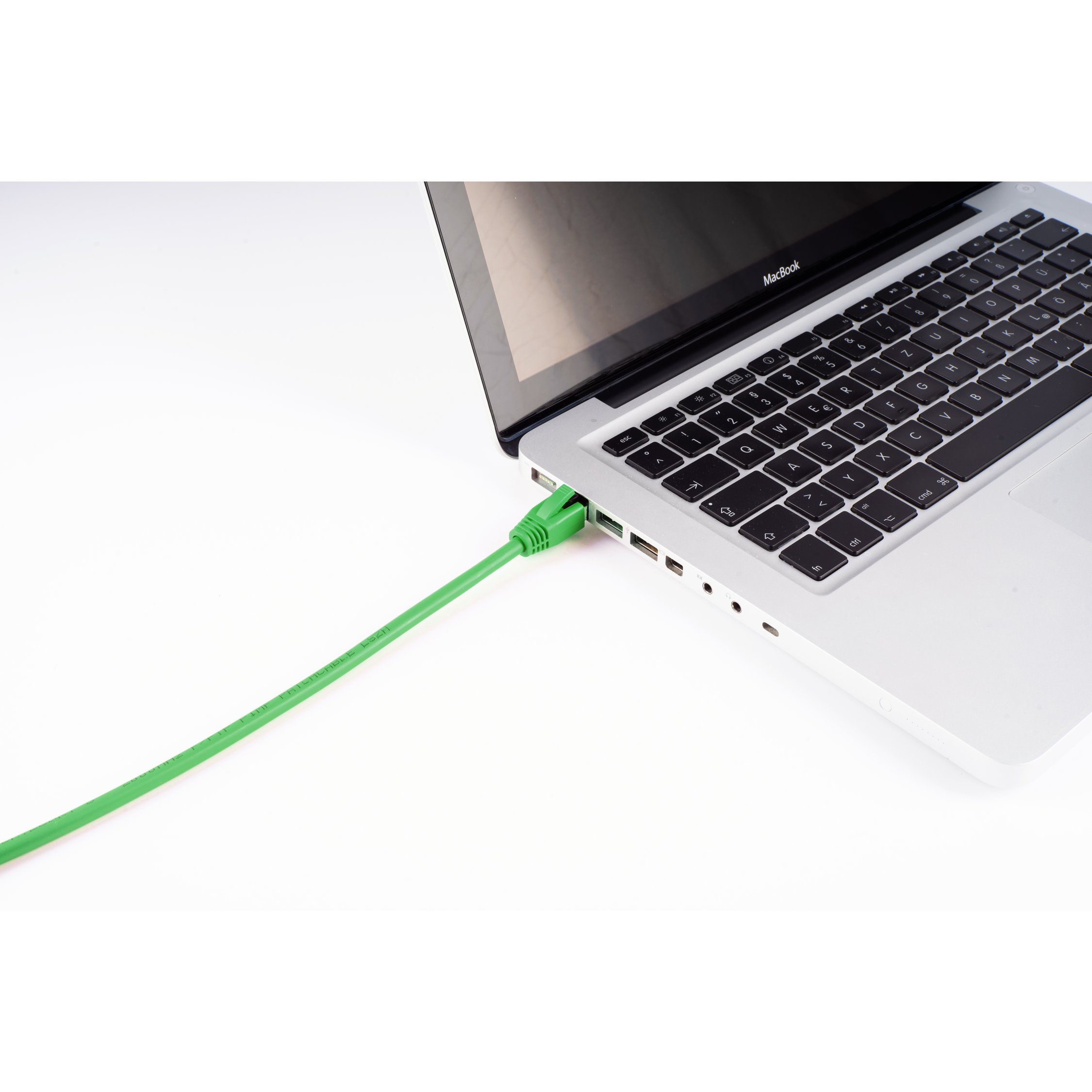 Cavo di rete verde collegato a un laptop su sfondo bianco.