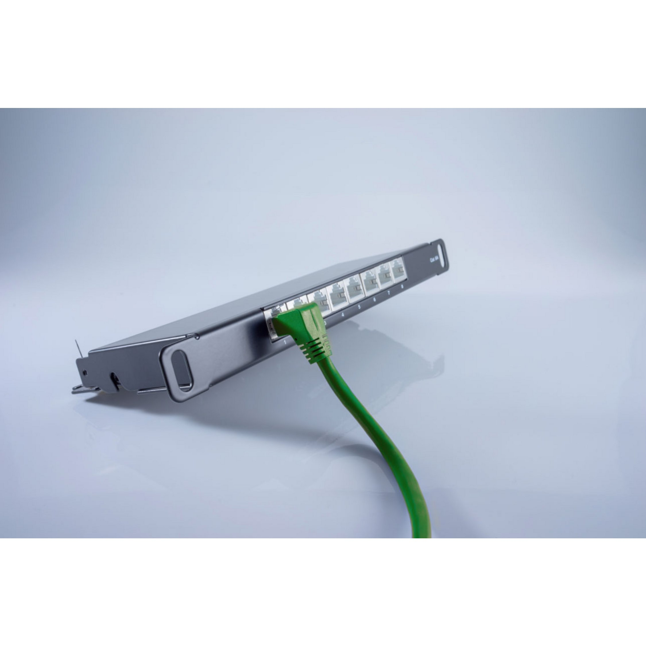 Schwarzer Netzwerk-Switch mit eingestecktem grünen Kabel, Winkelansicht, weißer Hintergrund.