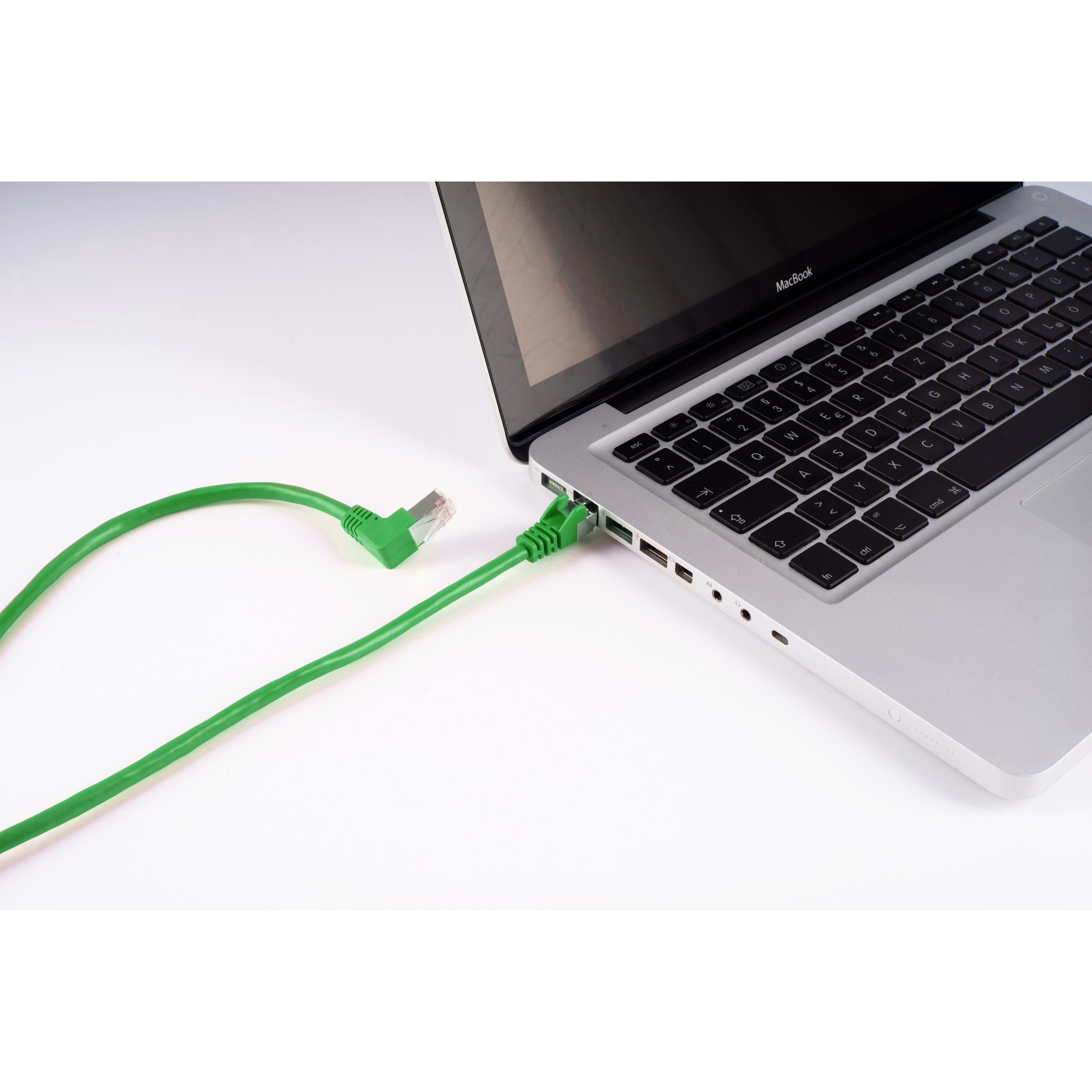 Ein grünes Ethernet-Kabel, das mit einem Laptop verbunden ist und den Anschluss zeigt.