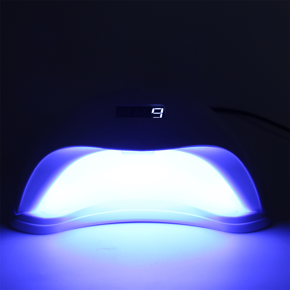Eine schwarze Nagellampe mit Digitalanzeige, die die Zahl 9 zeigt. Gibt blaues Licht ab.