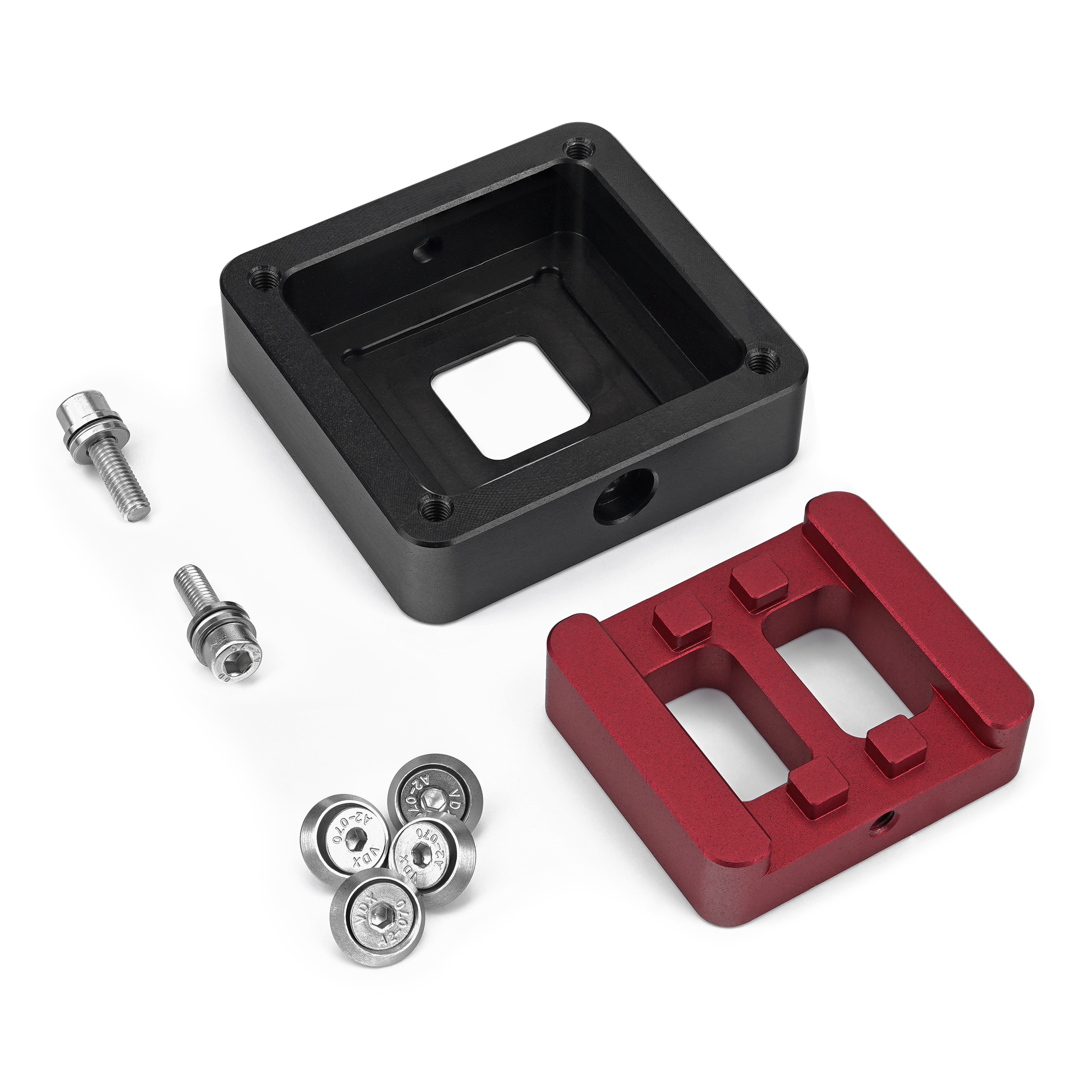 Schwarze und rote Metallteile mit Schrauben auf weißer Oberfläche.