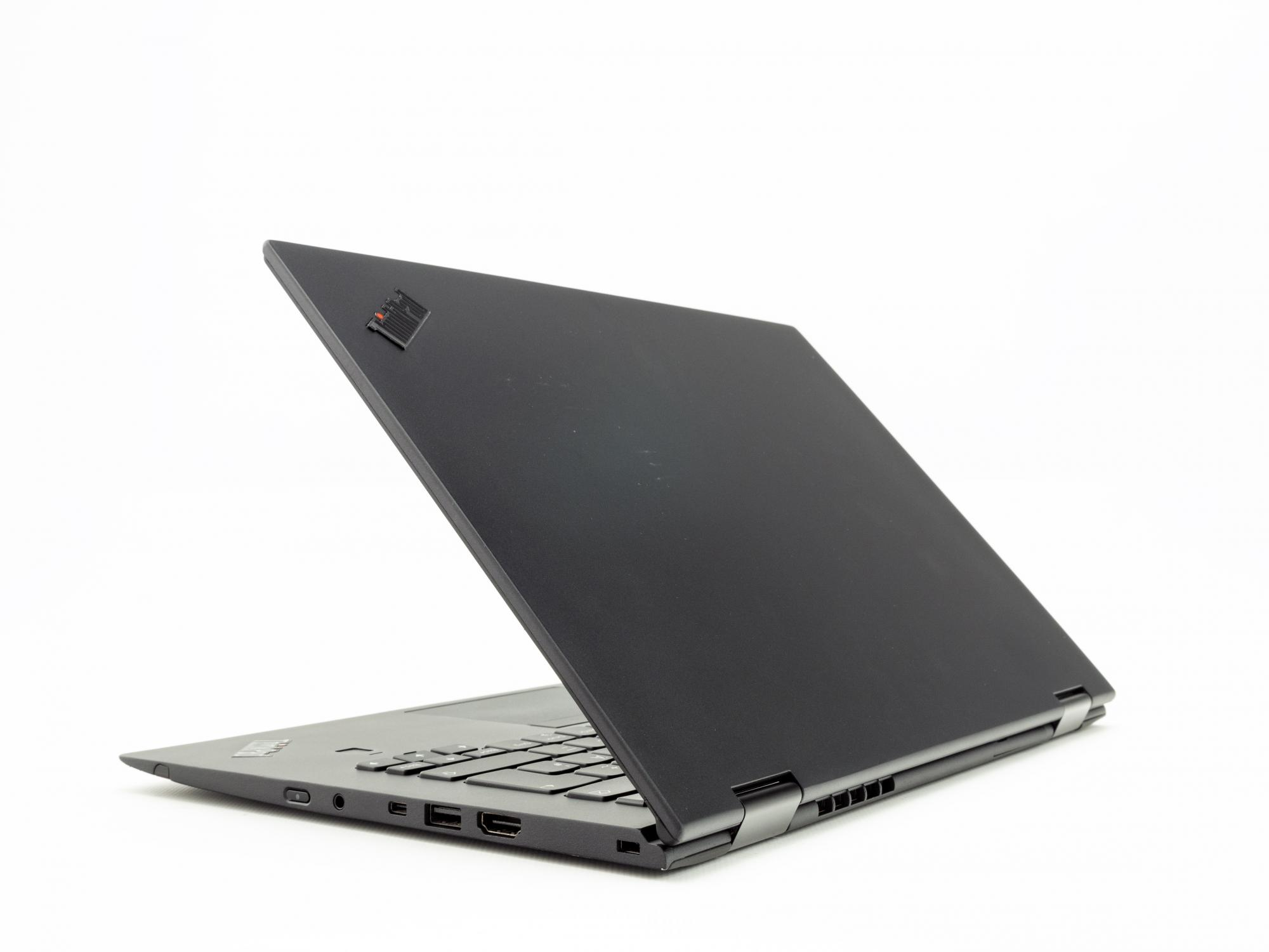 Schwarzer Laptop auf weißer Oberfläche. Der Laptop ist geöffnet und abgewinkelt, die Tastatur zeigend.