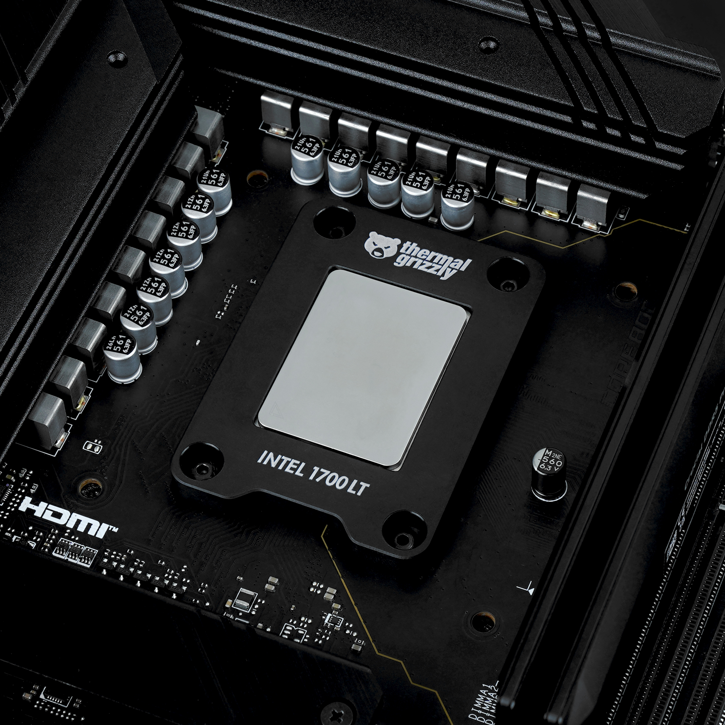 Schwarze PC-Komponente mit einer silbernen Platte mit der Aufschrift 'Thermal Grizzly Intel 1700 LT'.