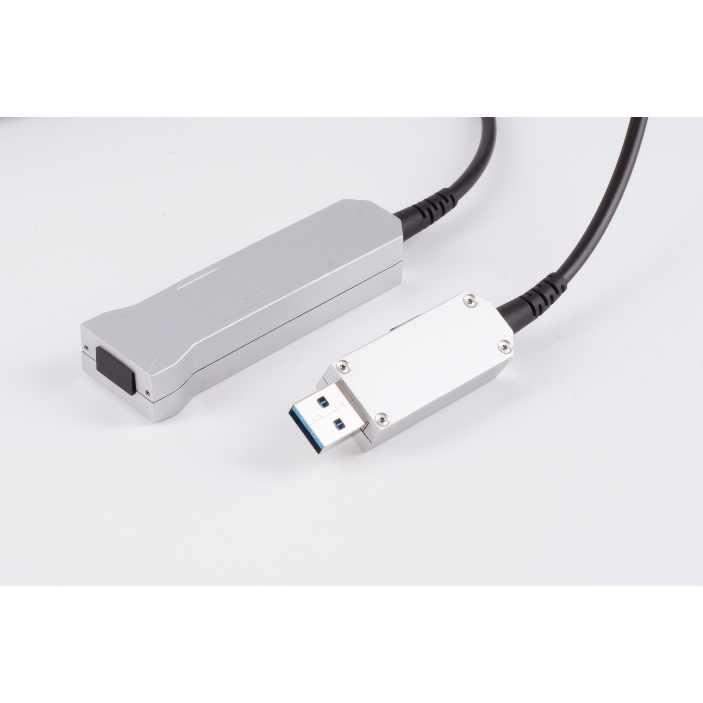 Adattatore USB argento e un cavo nero. L'adattatore è collegato a una scatola nera.