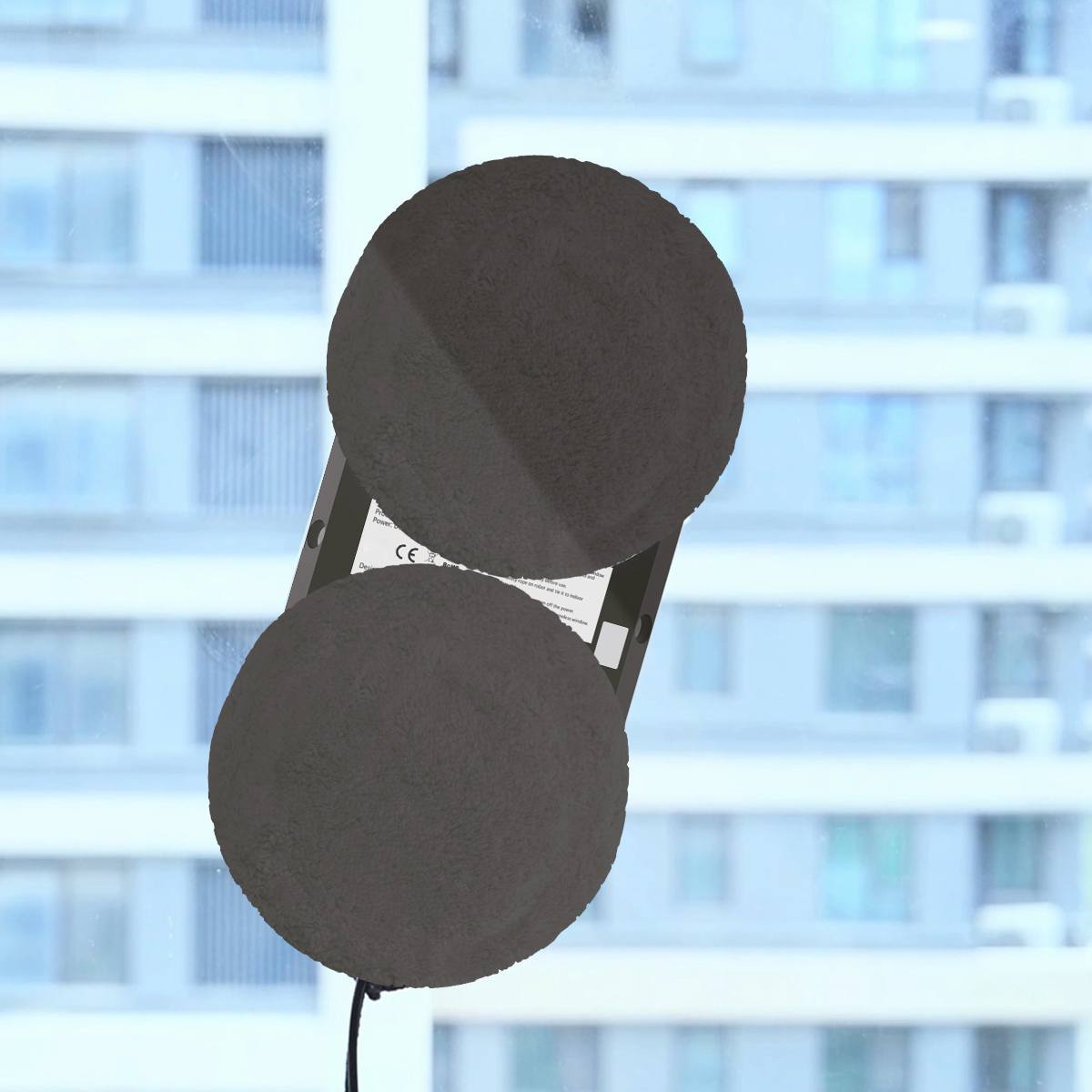 Robot do czyszczenia okien na oknie, ma dwie okrągłe podkładki czyszczące.