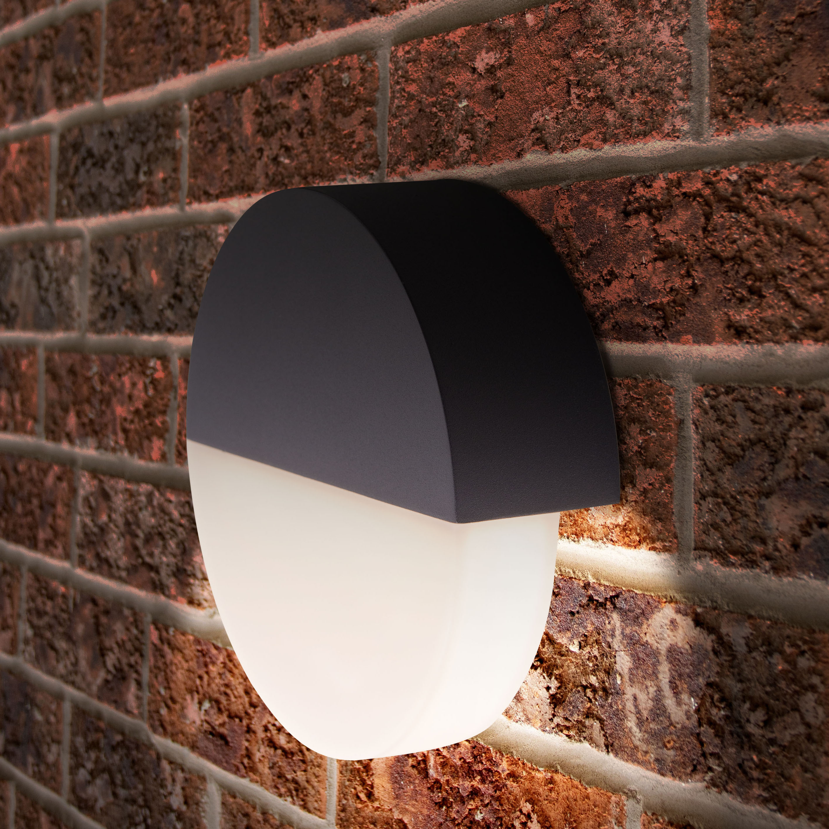 Schwarz-weiße Außenwandleuchte an einer Backsteinmauer, halbkreisförmiges Design.
