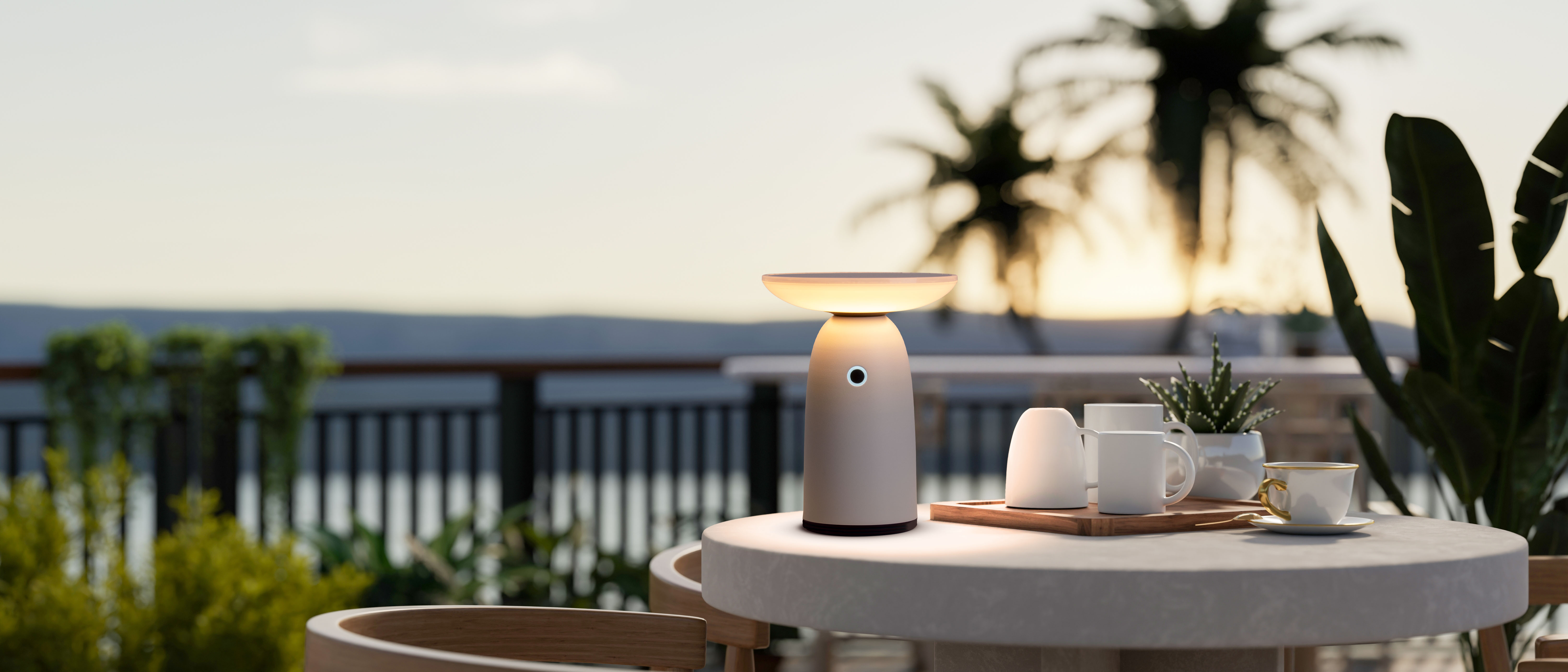 Ein Tisch für das Abendessen mit einer modernen Lampe, Tassen und Tellern auf einer Terrasse.