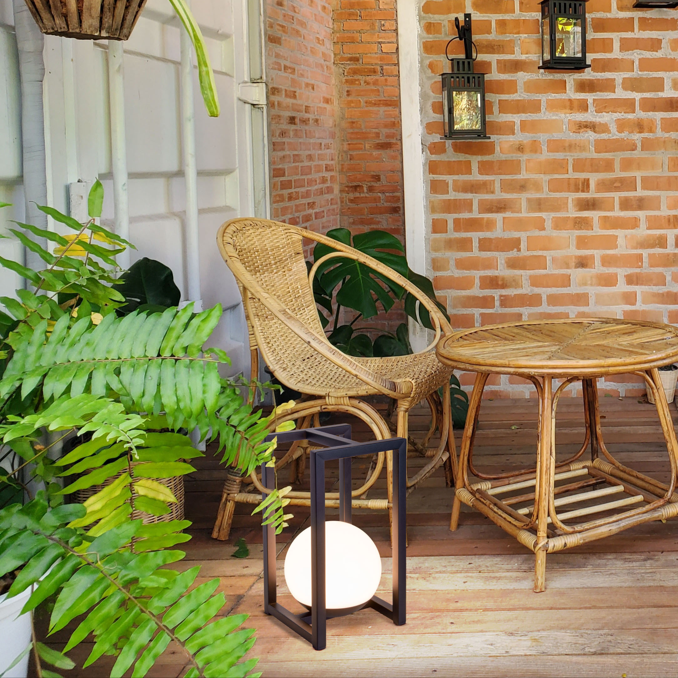 Eine Veranda mit einem Korbstuhl, einem Tisch und einer schwarzen Lampe mit Licht.