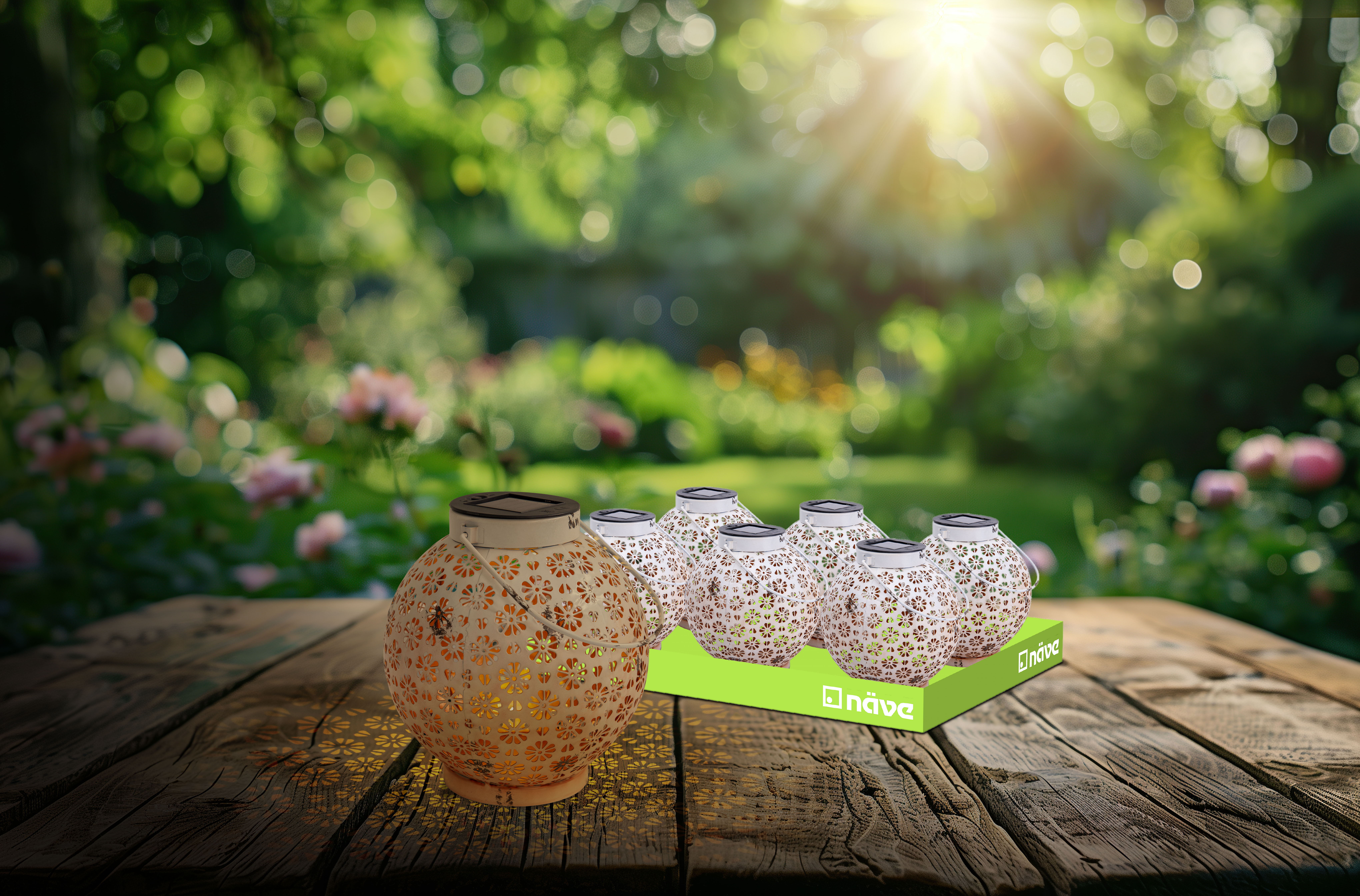 Mehrere Laternen auf einem Holztisch, in einem Garten mit grünem Laub und Sonnenlicht.