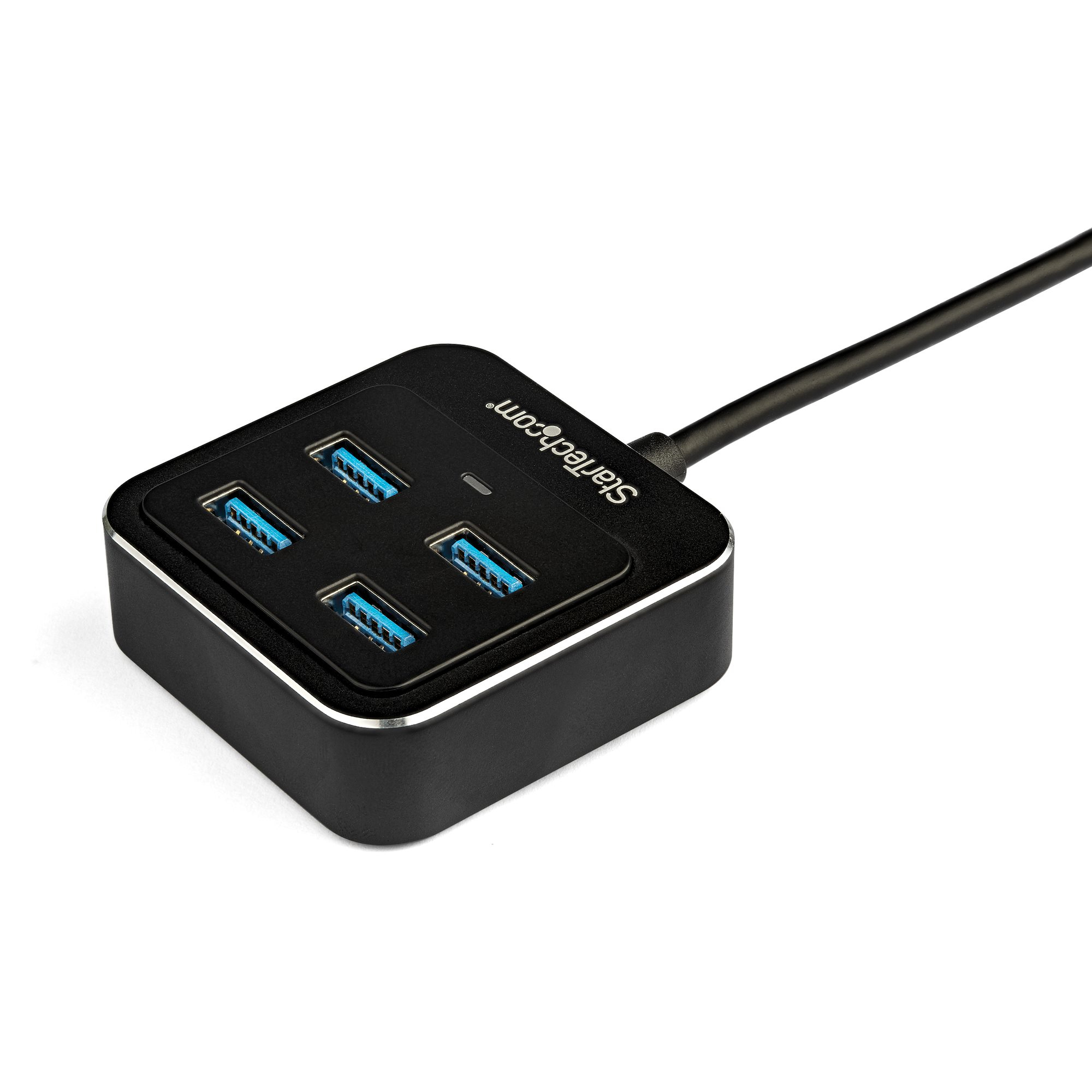 Concentrador USB negro con cuatro puertos USB azules, sobre una superficie blanca.