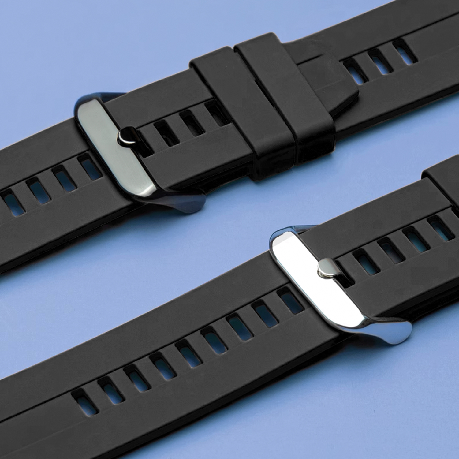 Dwa czarne paski do zegarków ze srebrnymi zapięciami. Niebieskie tło.